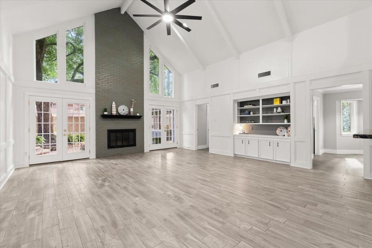 Step into an expansive living area with soaring
ceilings, a stylish bar, and stunning backyard views
through elegant French doors.
