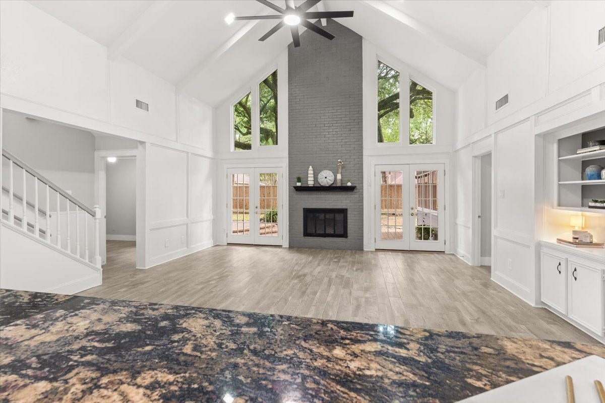 Spacious living area with new paint and flooring,
featuring built-in storage and a wet bar.