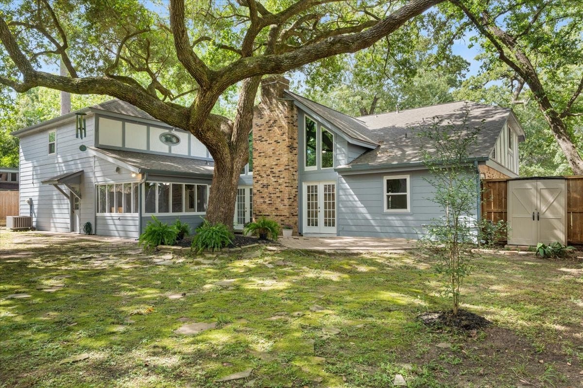 The yard features this lovely tree, patio, screened in sunroom, a small storage shed plus room to add much, much more!