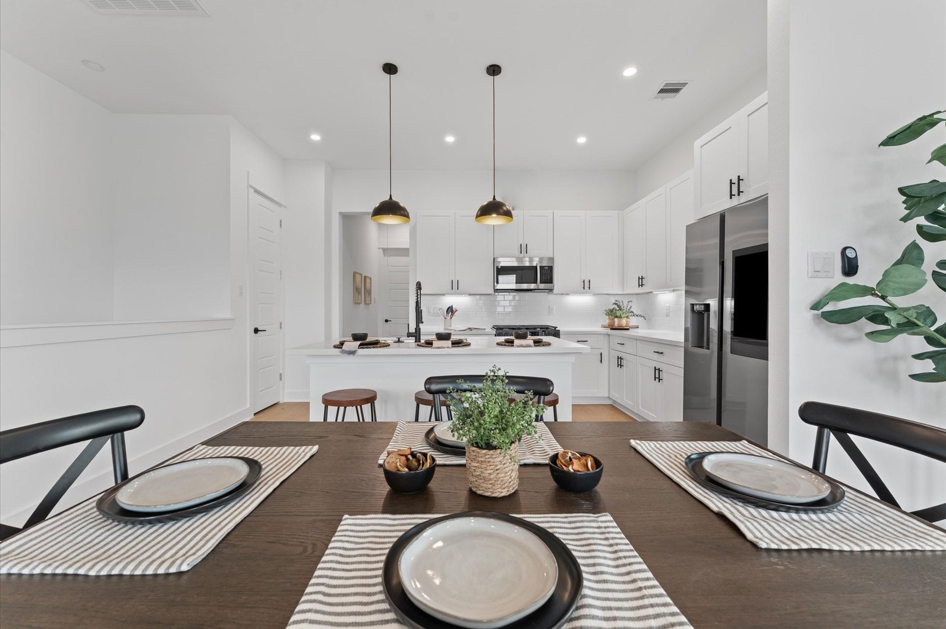 Elegant and inviting dining area designed for both everyday meals and special gatherings. The space features a well-proportioned layout that comfortably accommodates a full-size dining table, surrounded by stylish seating. Natural light filters in through nearby windows, highlighting the rooms neutral palette and contemporary finishes.
