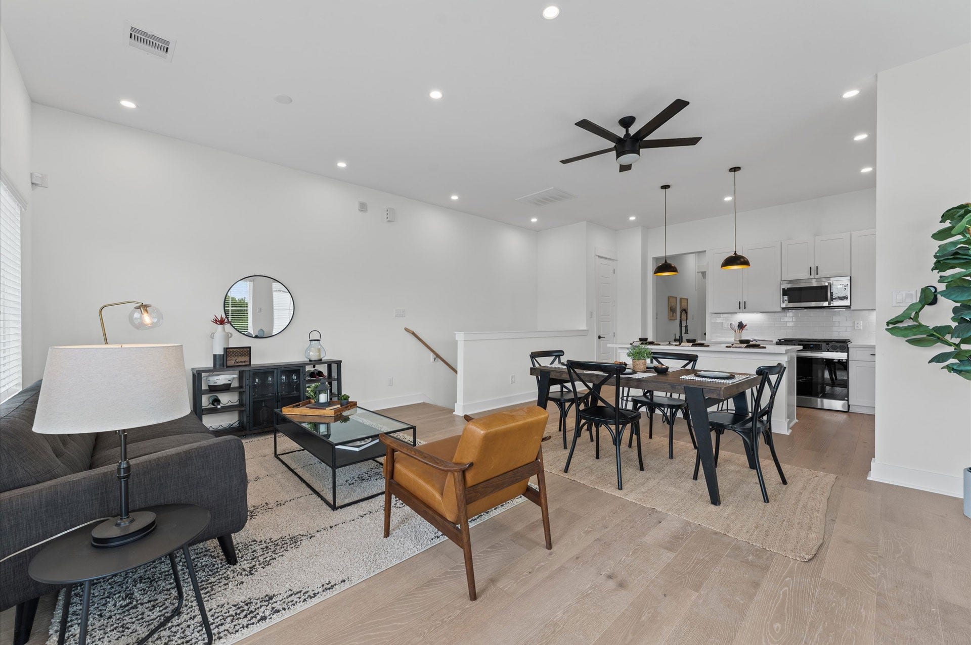 Perched on the second floor, this open-concept living, dining, and kitchen area flows effortlessly beneath high ceilings and across rich engineered hardwood floors that unify the space with warmth and elegance.