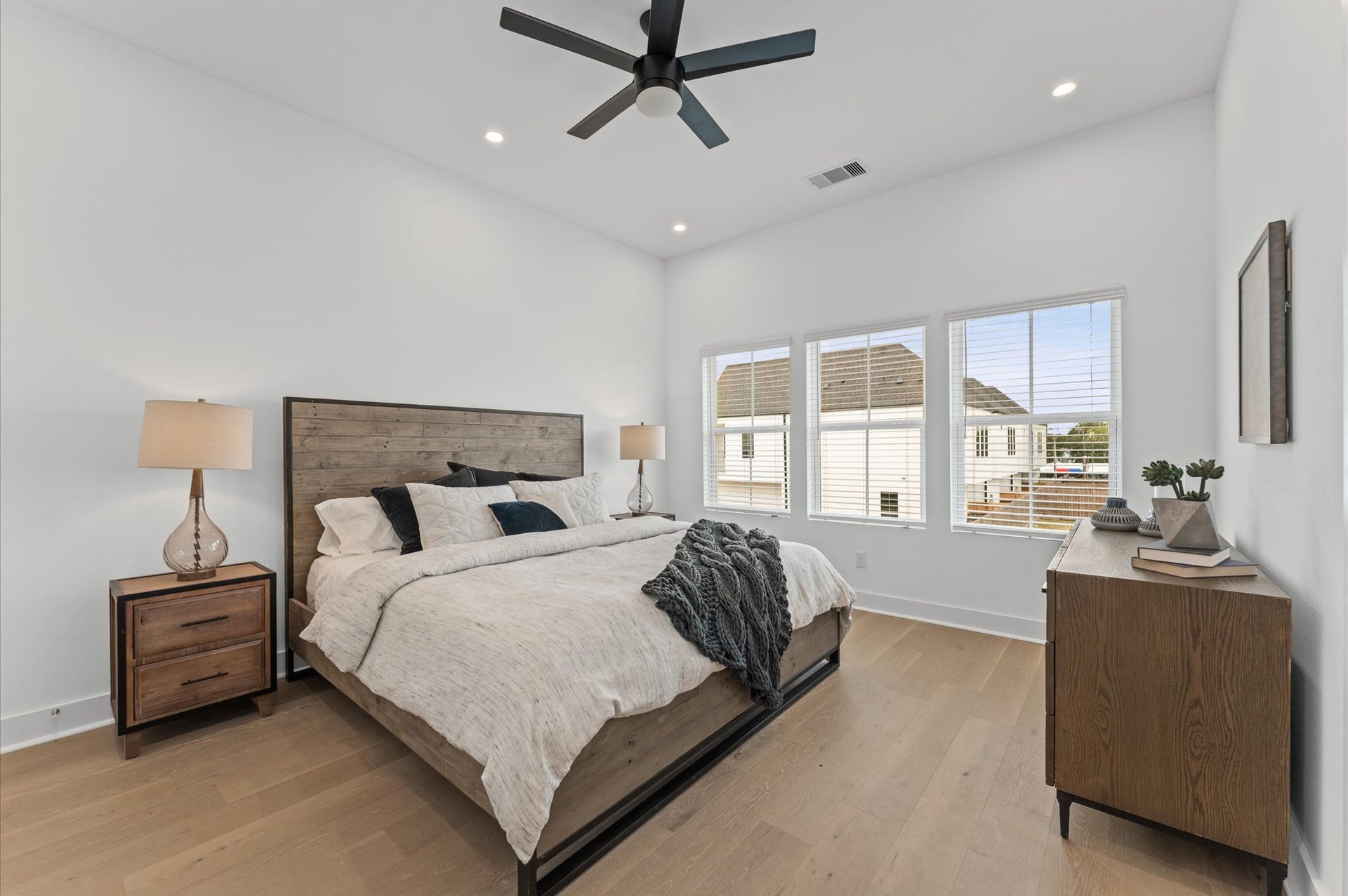 This spacious second-floor primary bedroom exudes modern elegance with its sleek engineered wood flooring that adds warmth and texture underfoot. High ceilings and big windows amplify the sense of openness, allowing natural light to cascade in and highlight the rooms charm. Whether styled with minimalist furnishings or layered with cozy accents, the space offers a serene retreat.