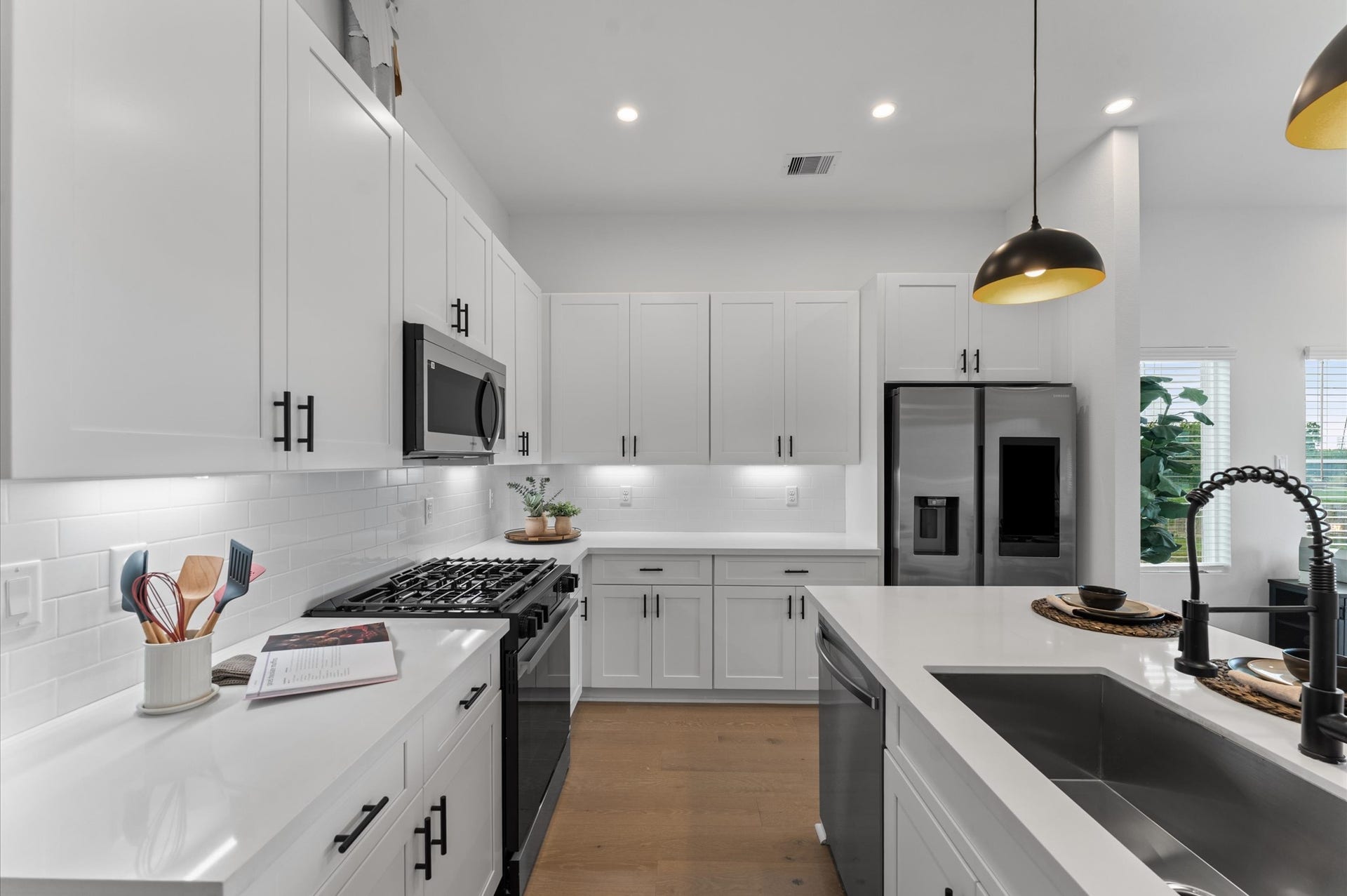 This modern kitchen is a masterclass in both style and functionality, featuring abundant cabinetry along the walls and a spacious island with built-in storage. The cabinetry offers generous room for cookware, pantry items, and small appliances, while the island includes drawers and cabinets that maximize organization and prep space. Sleek stainless-steel appliances, blend seamlessly into the design, enhancing the kitchens polished aesthetic.