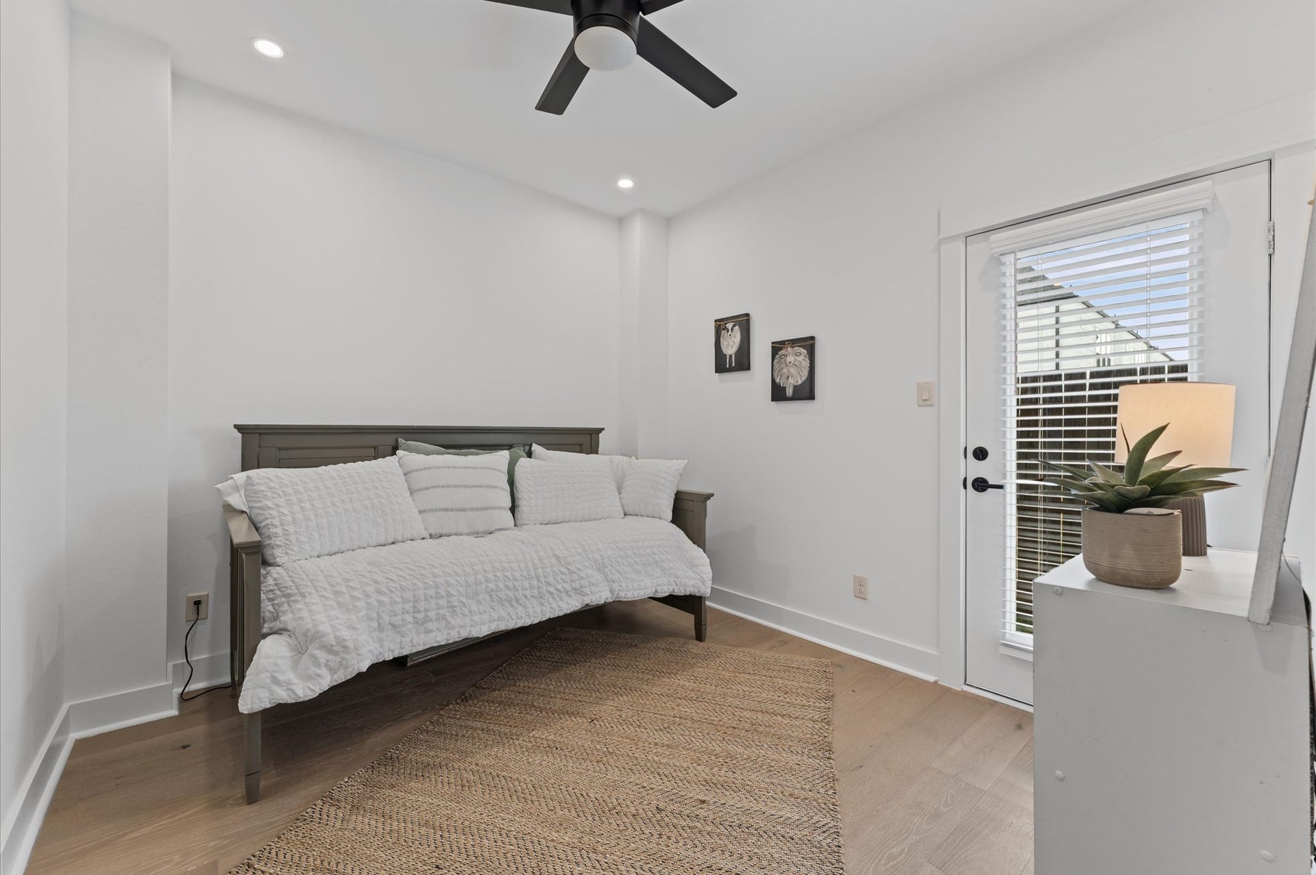 Stylish and versatile secondary bedroom situated on the first floor, offering direct access to the backyard through elegant glass patio door. This sunlit space features warm-toned flooring, soft neutral walls, and generous room for a queen-sized bed and additional furnishings. Outdoor access enhances the rooms appeal for relaxation, remote work, guest room.