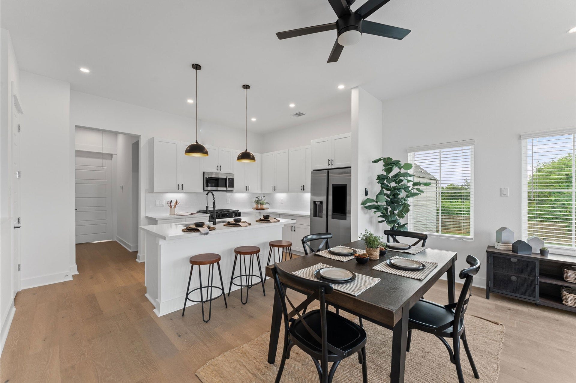 Elegant and inviting dining area designed for both everyday meals and special gatherings. The space features a well-proportioned layout that comfortably accommodates a full-size dining table, surrounded by stylish seating. Natural light filters in through nearby windows, highlighting the rooms neutral palette and contemporary finishes.