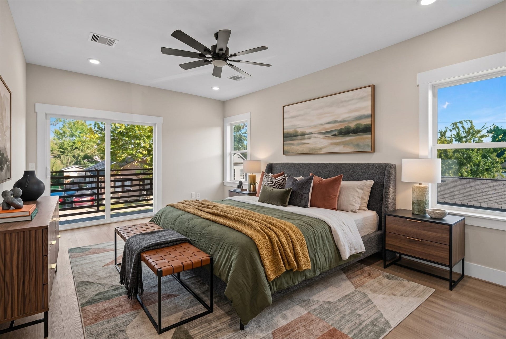 2412 Terry Street, #B, Houston, TX 77009 Virtually Staged: This spacious primary bedroom offers a light-filled retreat with high ceilings, a contemporary ceiling fan, and recessed overhead lighting.