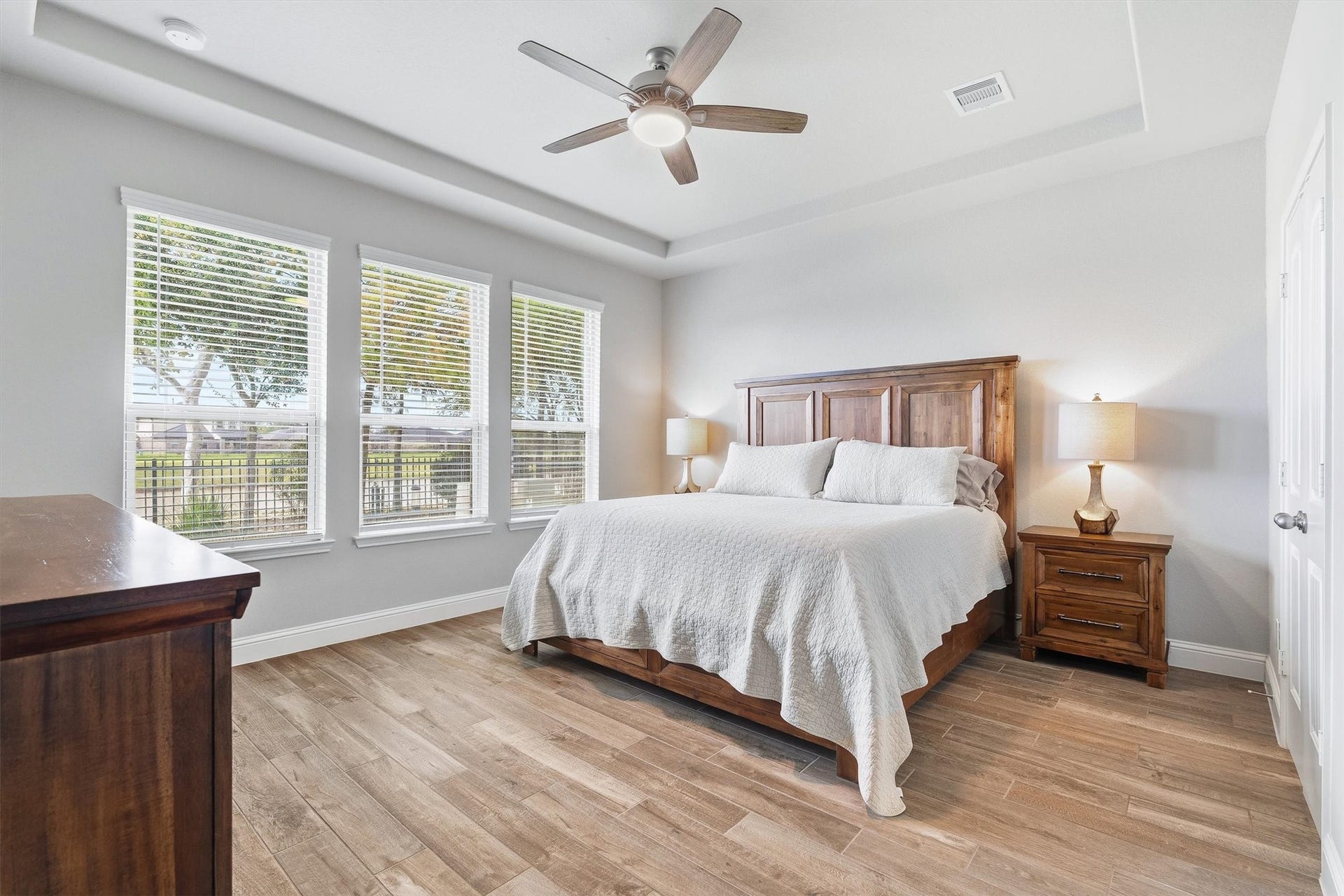 9034 Japonica Drive, Rosenberg, TX 77469 Wake up to serene lake views from this spacious primary suite, featuring elegant tray ceilings and walls of windows that flood the room with natural light.