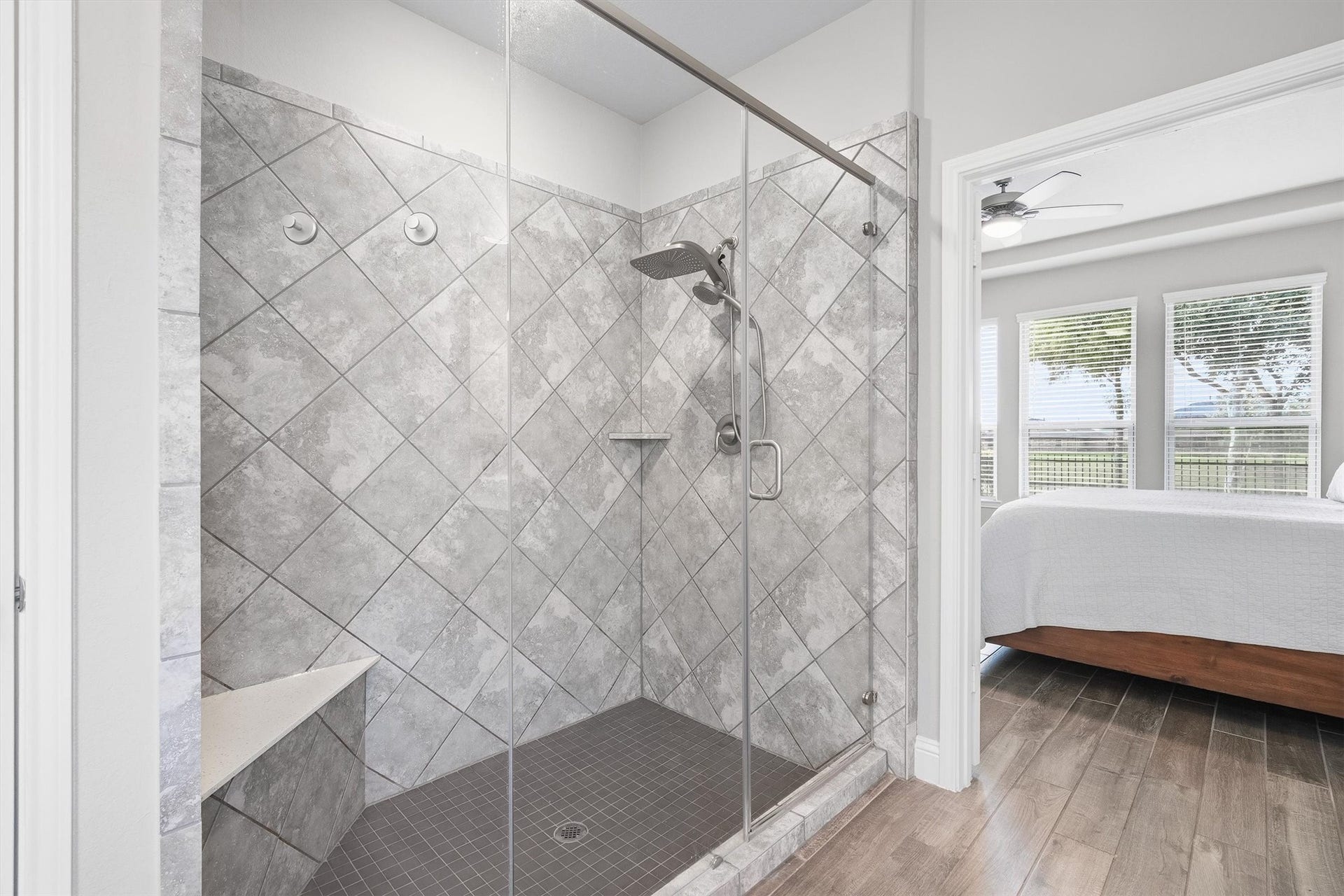 9034 Japonica Drive, Rosenberg, TX 77469 Unwind in the expansive glass-enclosed walk-in shower featuring beautiful diagonal gray tilework.