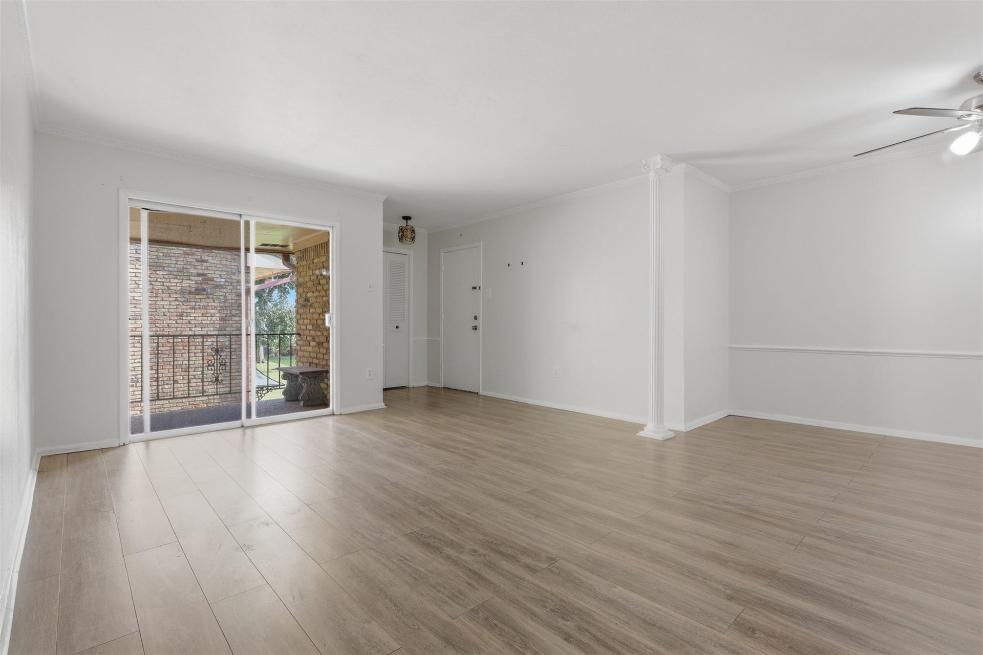 7600 Burgoyne Road, #250, Houston, TX 77063 Bright and inviting living space with sleek wood floors, abundant natural light, and seamless access to a charming outdoor balcony.