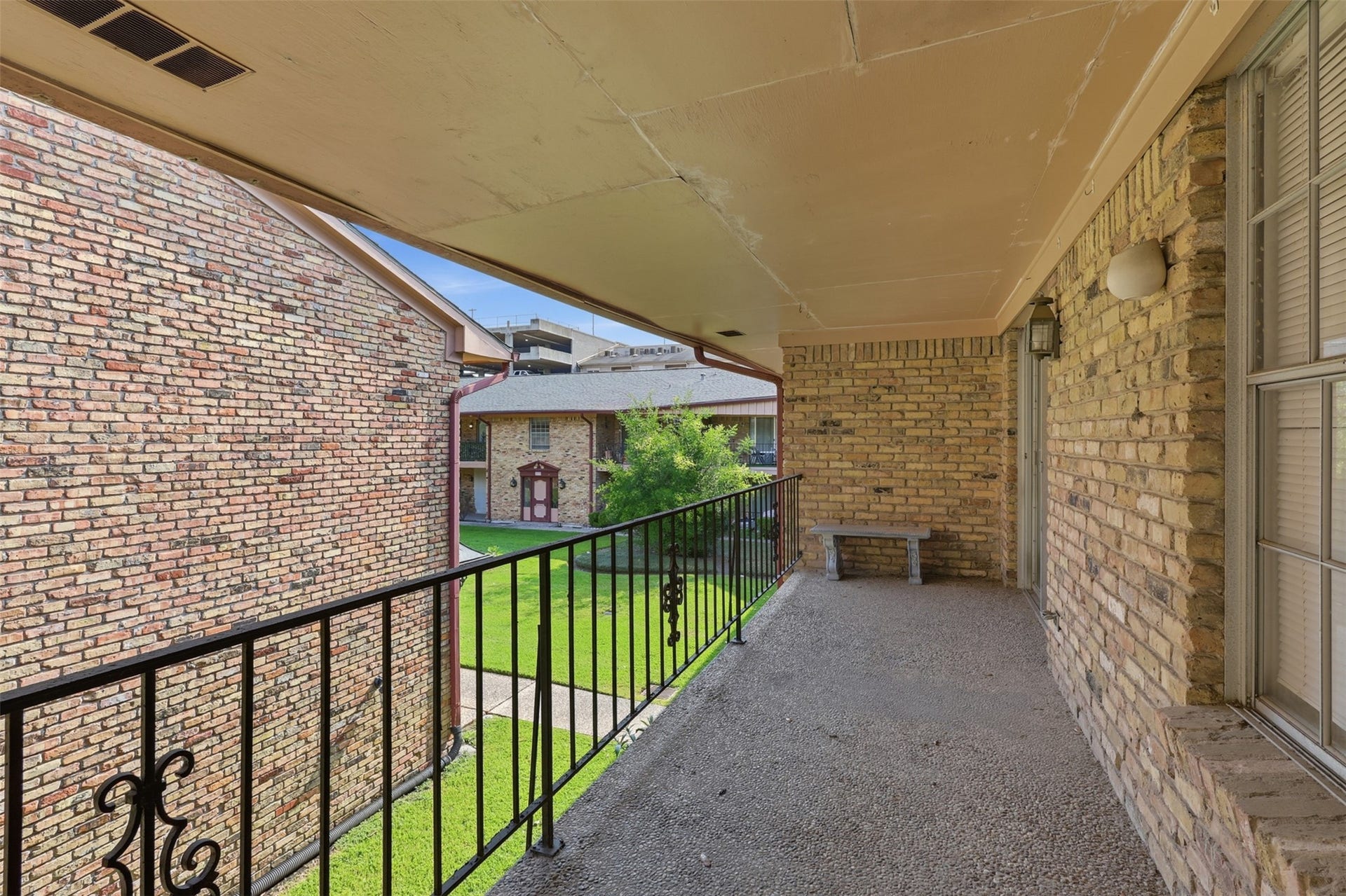 7600 Burgoyne Road, #250, Houston, TX 77063 Charming balcony offering a serene view of the courtyard, perfect for relaxing and enjoying the outdoors.