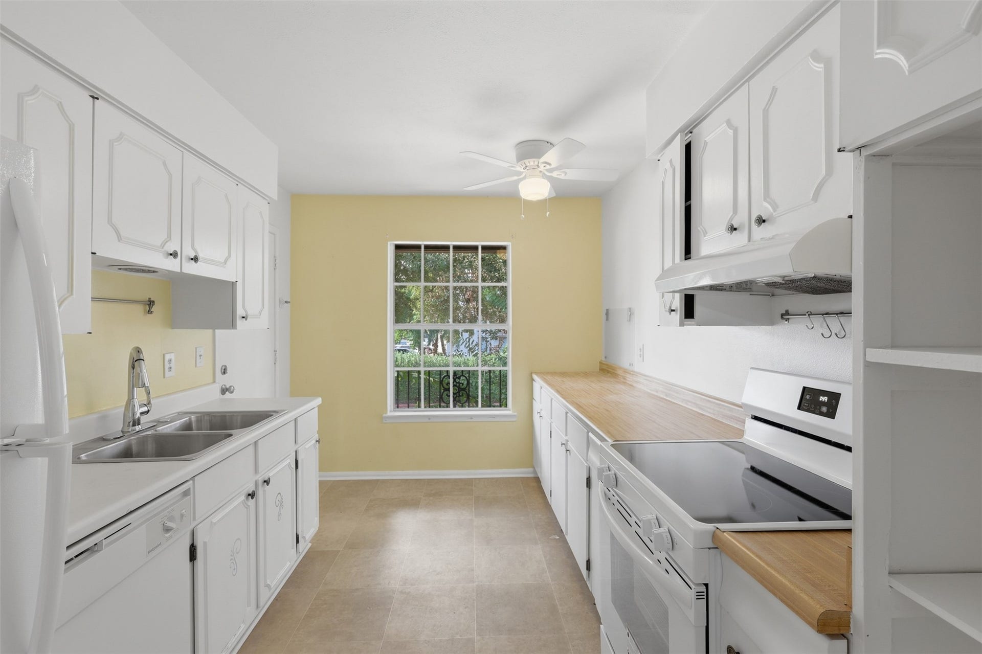 7600 Burgoyne Road, #250, Houston, TX 77063 Bright and inviting kitchen with ample counter space, classic cabinetry, and a charming window view perfect for culinary creativity.