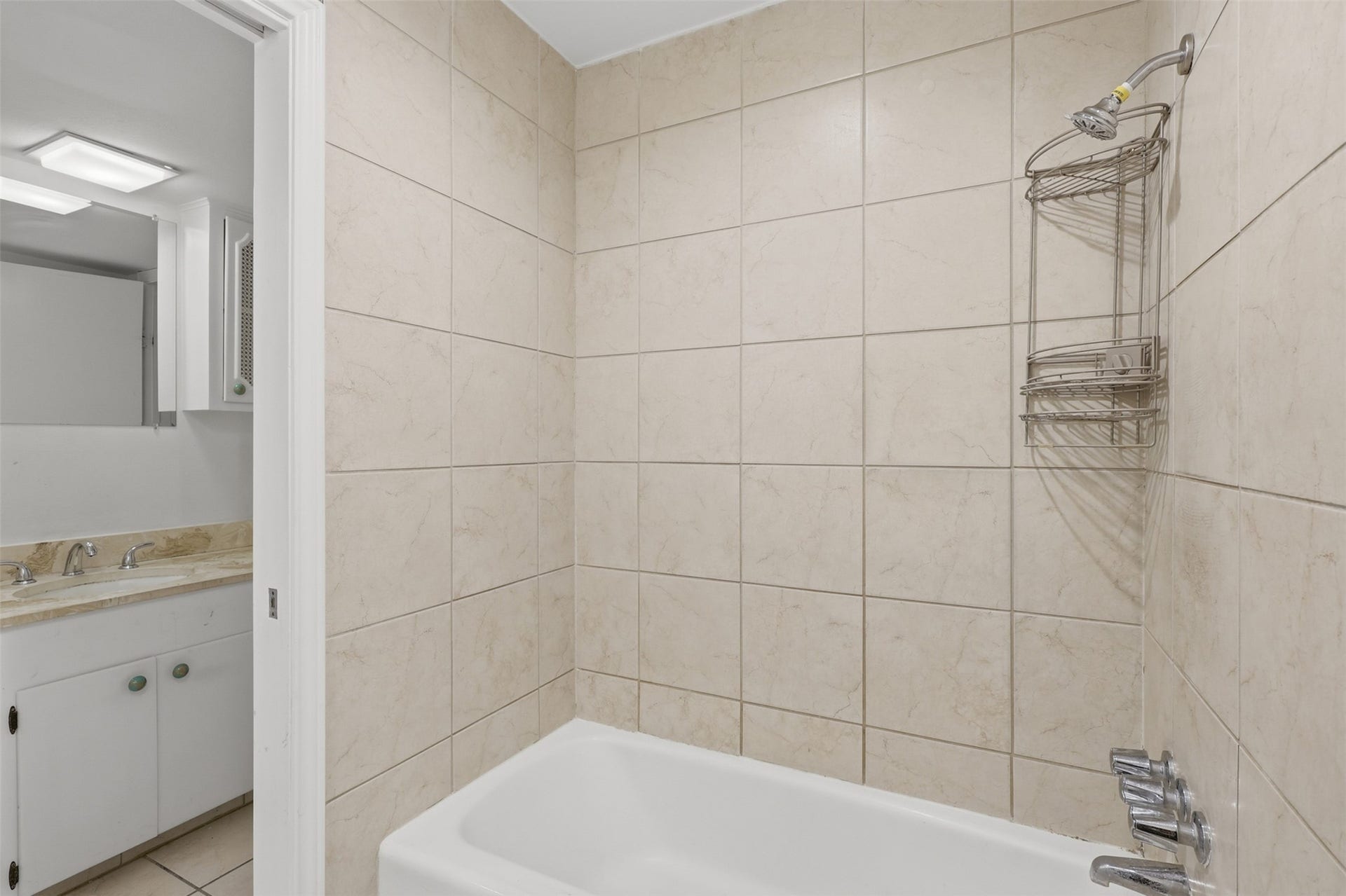 7600 Burgoyne Road, #250, Houston, TX 77063 Indulge in the elegance of this primary bathroom, featuring sleek tile work and a modern shower-bathtub combo, all complemented by a sophisticated vanity area.