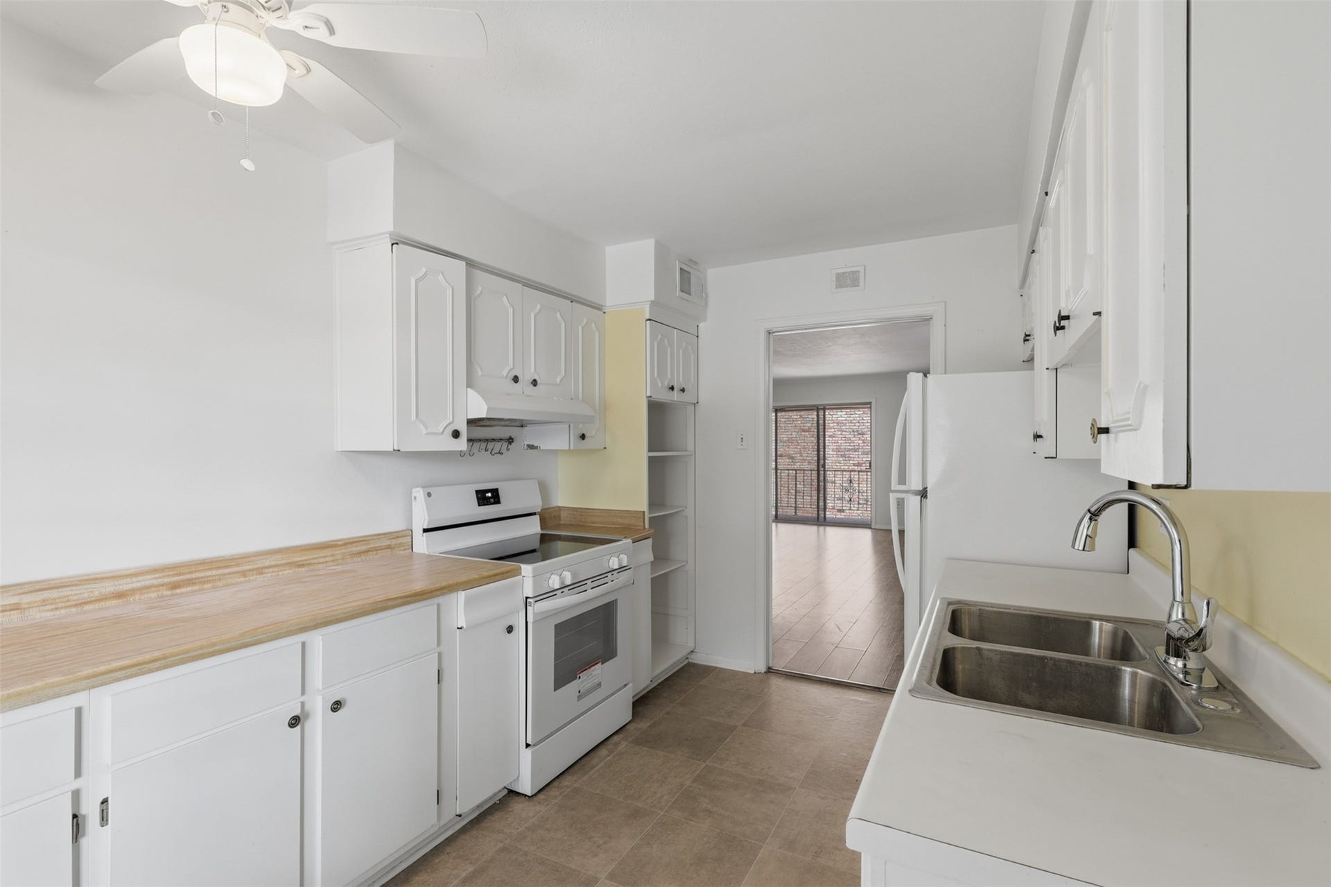 7600 Burgoyne Road, #250, Houston, TX 77063 Bright and inviting, this kitchen features classic white cabinetry, ample counter space, and modern appliances, seamlessly connecting to the living area for easy entertaining.