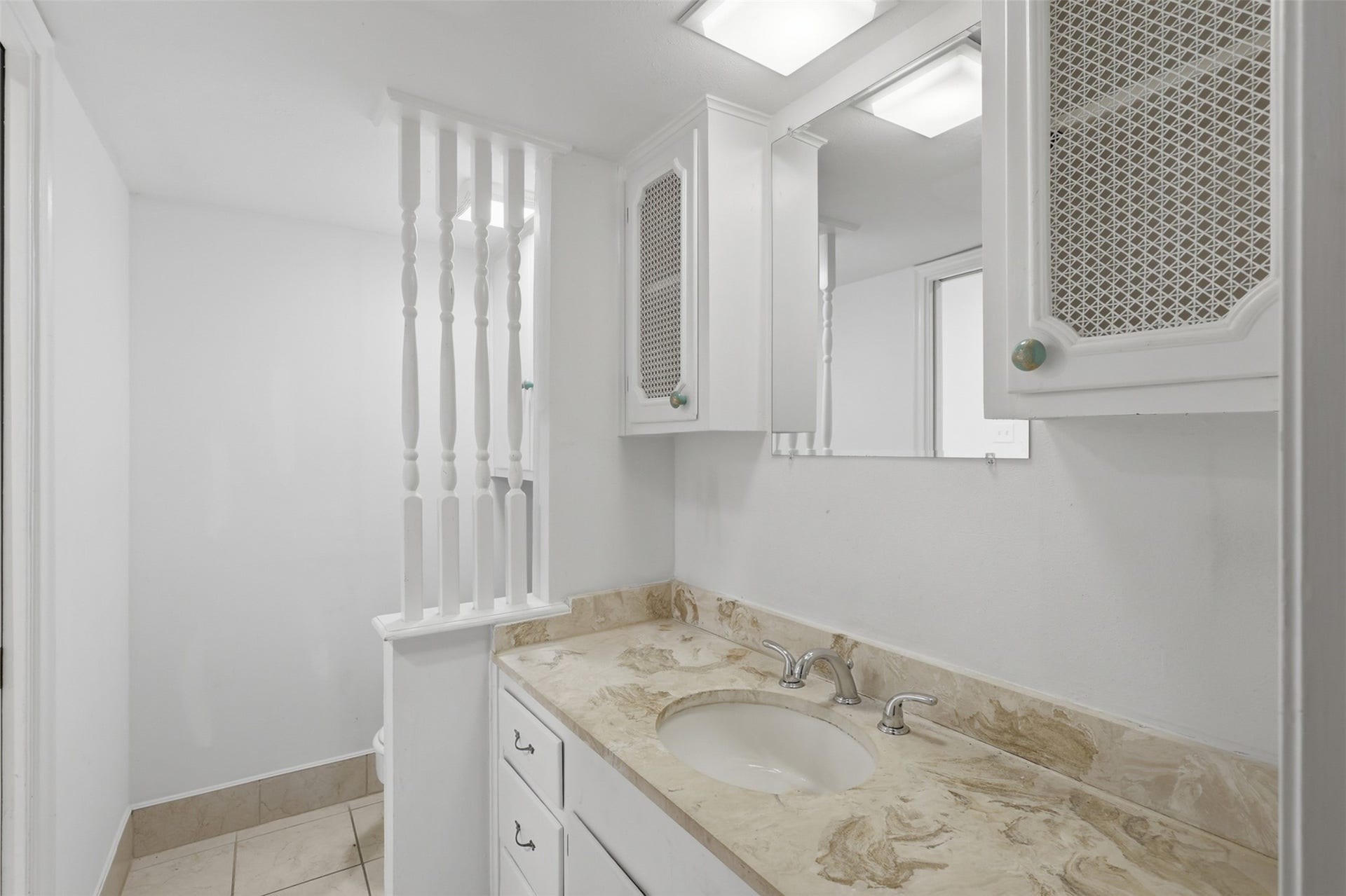 7600 Burgoyne Road, #250, Houston, TX 77063 Elegant half bathroom featuring a stylish marble countertop, ample storage, and a bright, clean design that enhances functionality and charm.