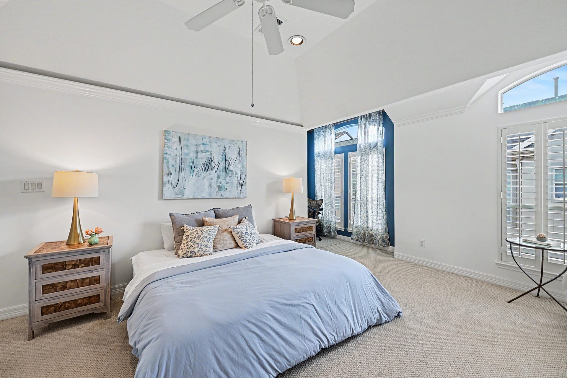 Primary bedroom with vaulted ceilings, ample natural light and an office nook tucked away in the corner