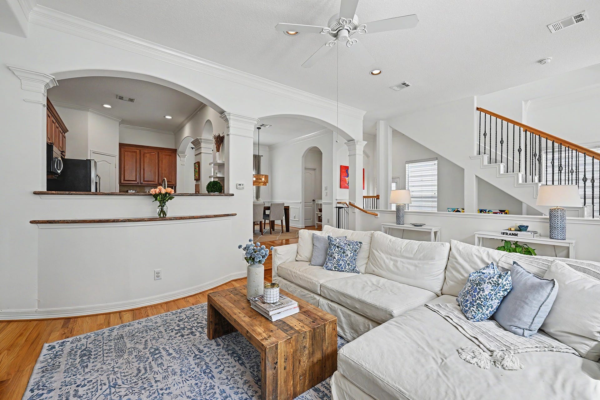 Sunny open living room features hardwood floors, art nooks and fireplace