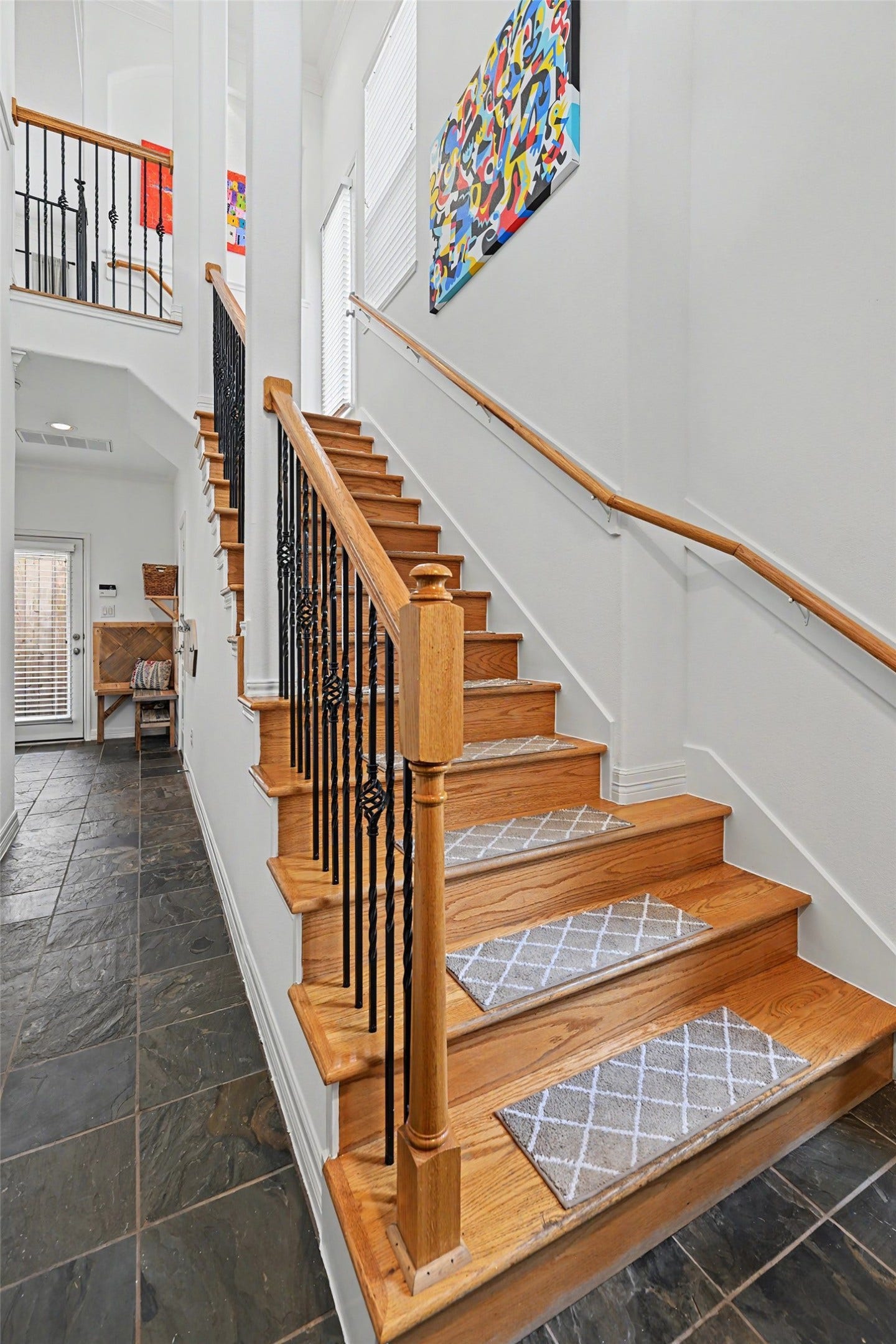 Greetings at the front door with a secondary bed, ensuite bath, patio entry and drop zone toward the back. There is also a massive closet under the stairs.
