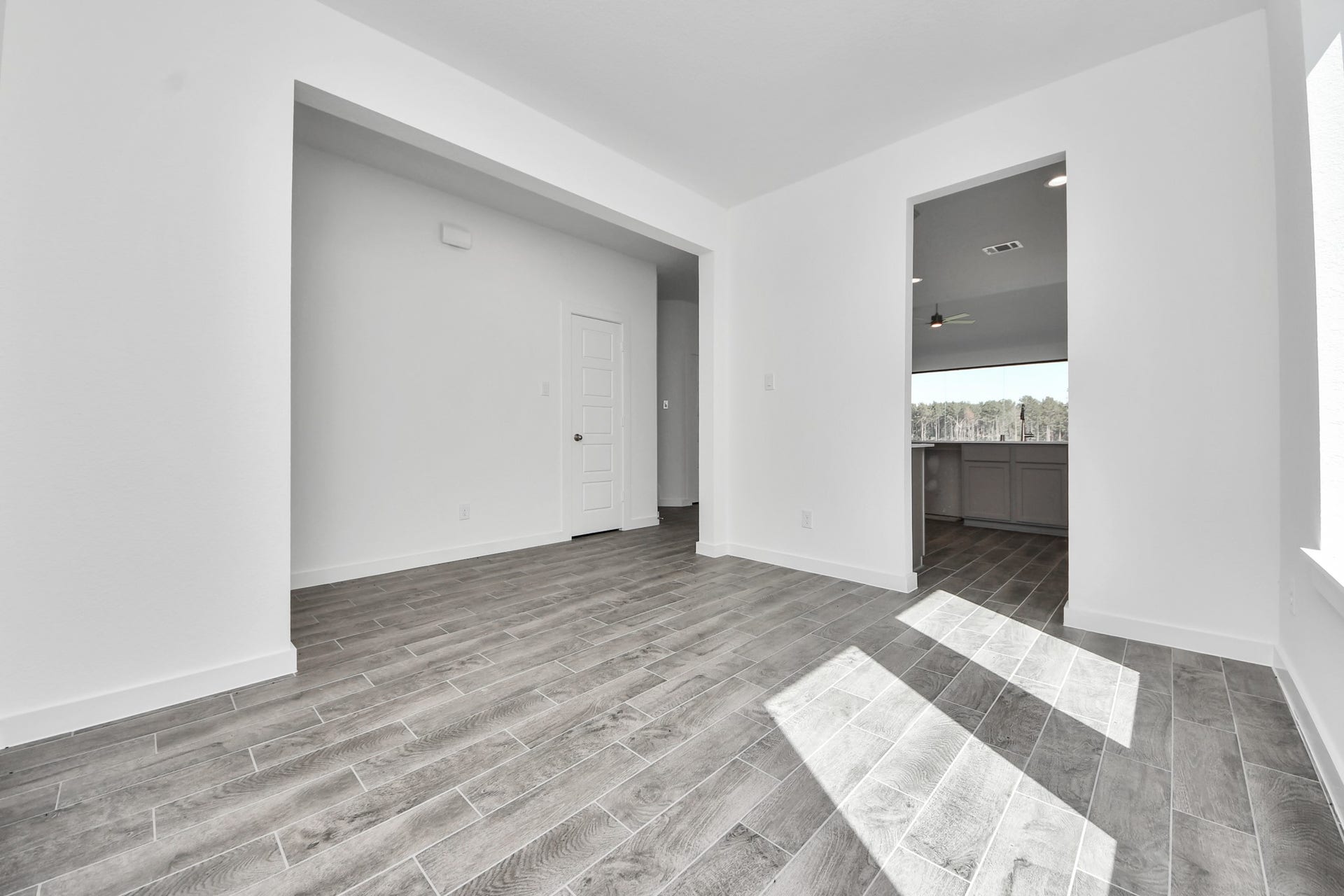 1017 Golden Glow Path, Magnolia, TX 77355 Create lasting memories with your family and friends at the dining table! This expansive dining room showcases sophisticated flooring, custom paint, and seamlessly connects to the family room and kitchen, providing an open and inviting atmosphere