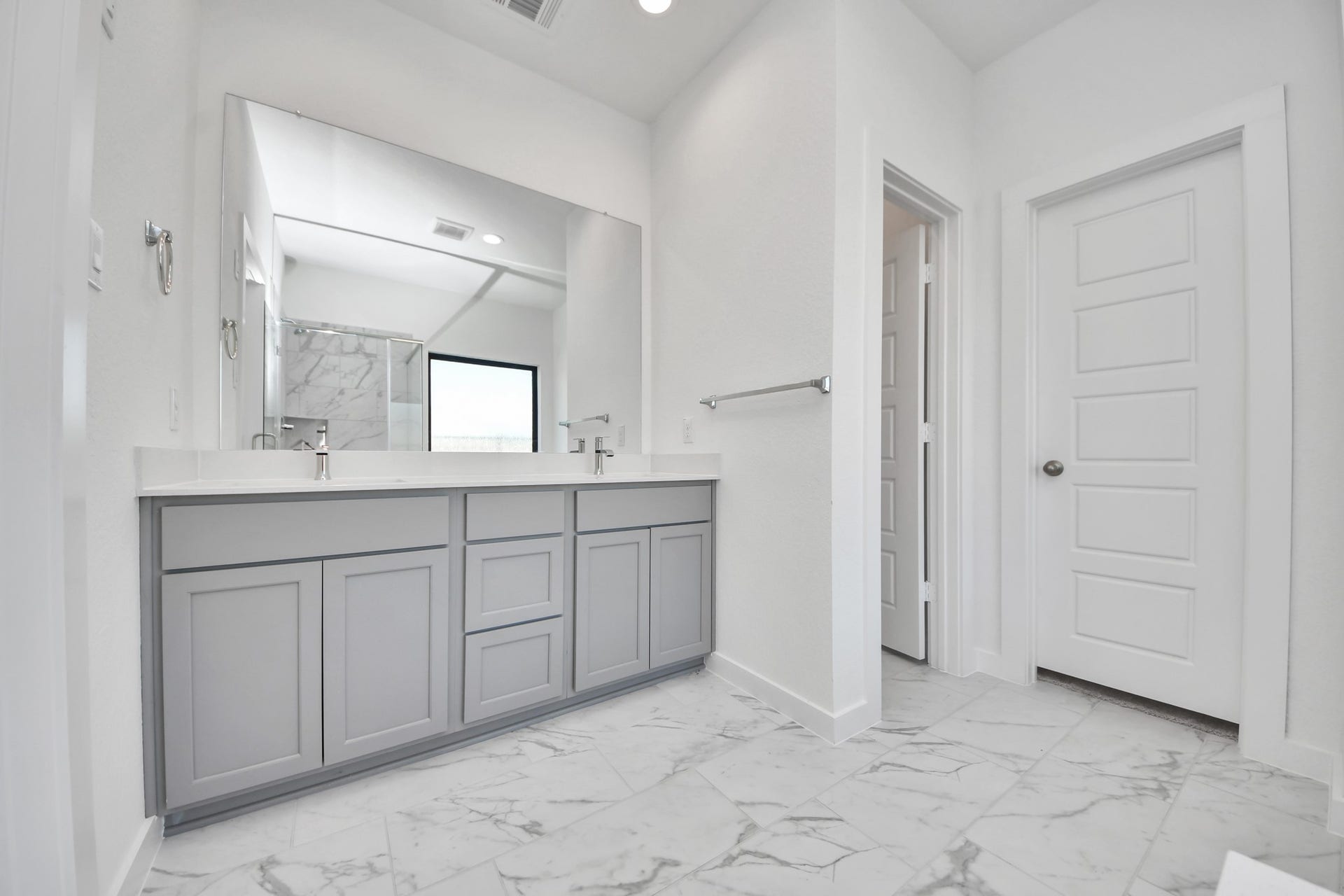 1017 Golden Glow Path, Magnolia, TX 77355 Escape to a spa-like oasis in this primary bathroom. Enjoy a walk-in shower with tile surround, a separate garden tub with custom detailing, and an elegant vanity featuring light countertops, modern hardware, and beautiful vanity lights. Experience luxury and relaxation in every detail.