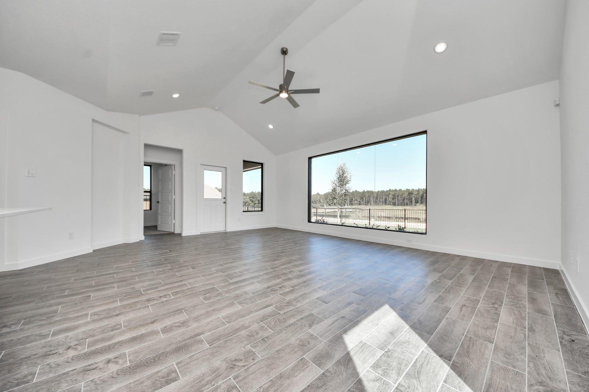 1017 Golden Glow Path, Magnolia, TX 77355 Welcome family and guests to your charming living room! With its high ceilings, recessed lighting, ceiling fan, custom paint, beautiful flooring, and large windows that let in abundant natural light, this room is perfect for gatherings.
