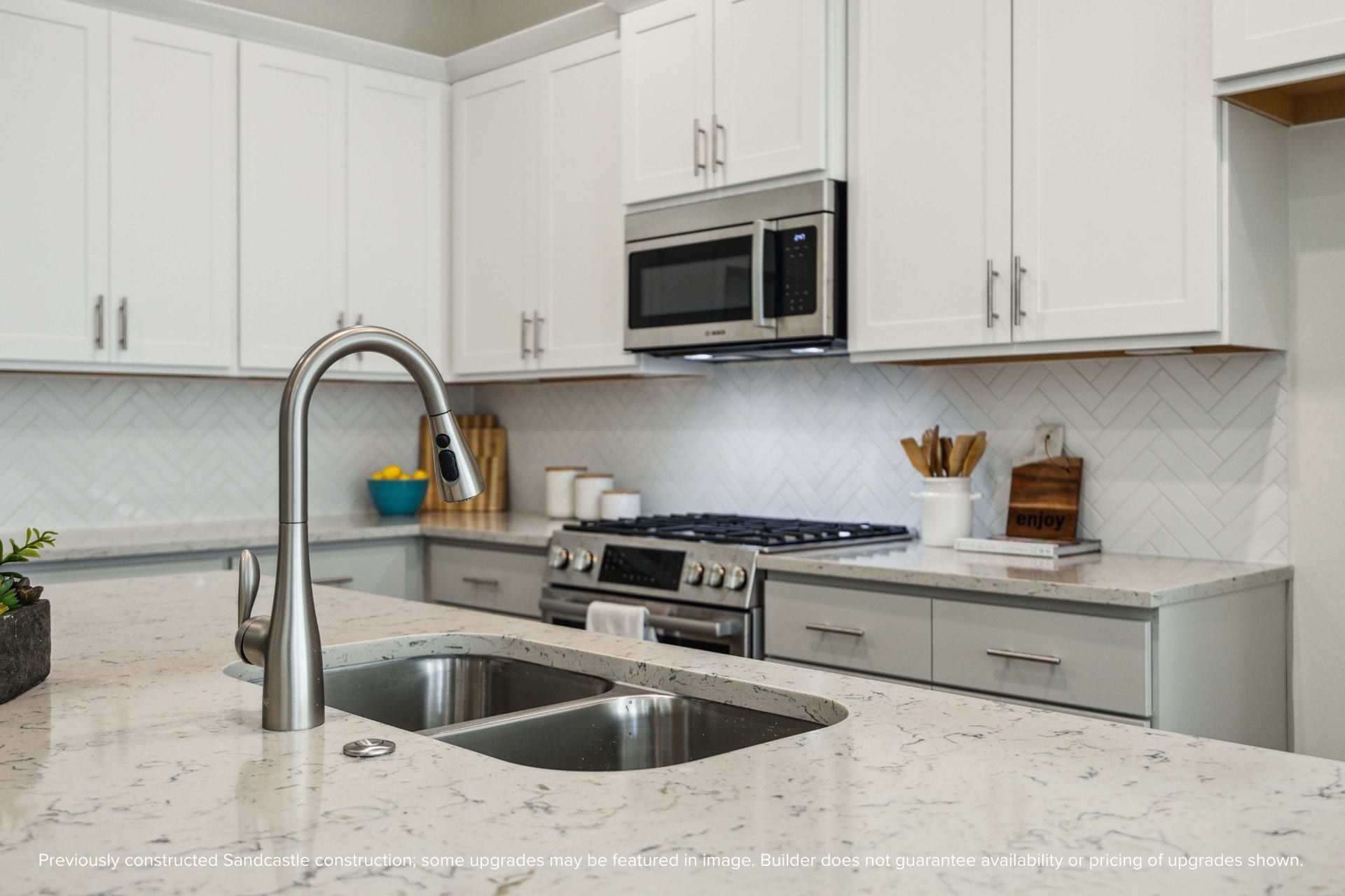From the stainless steel undermount sink to the Moen pull-down faucet, every detail here feels elevated. Designer-selected backsplashes add just the right touch of texture and personality.
