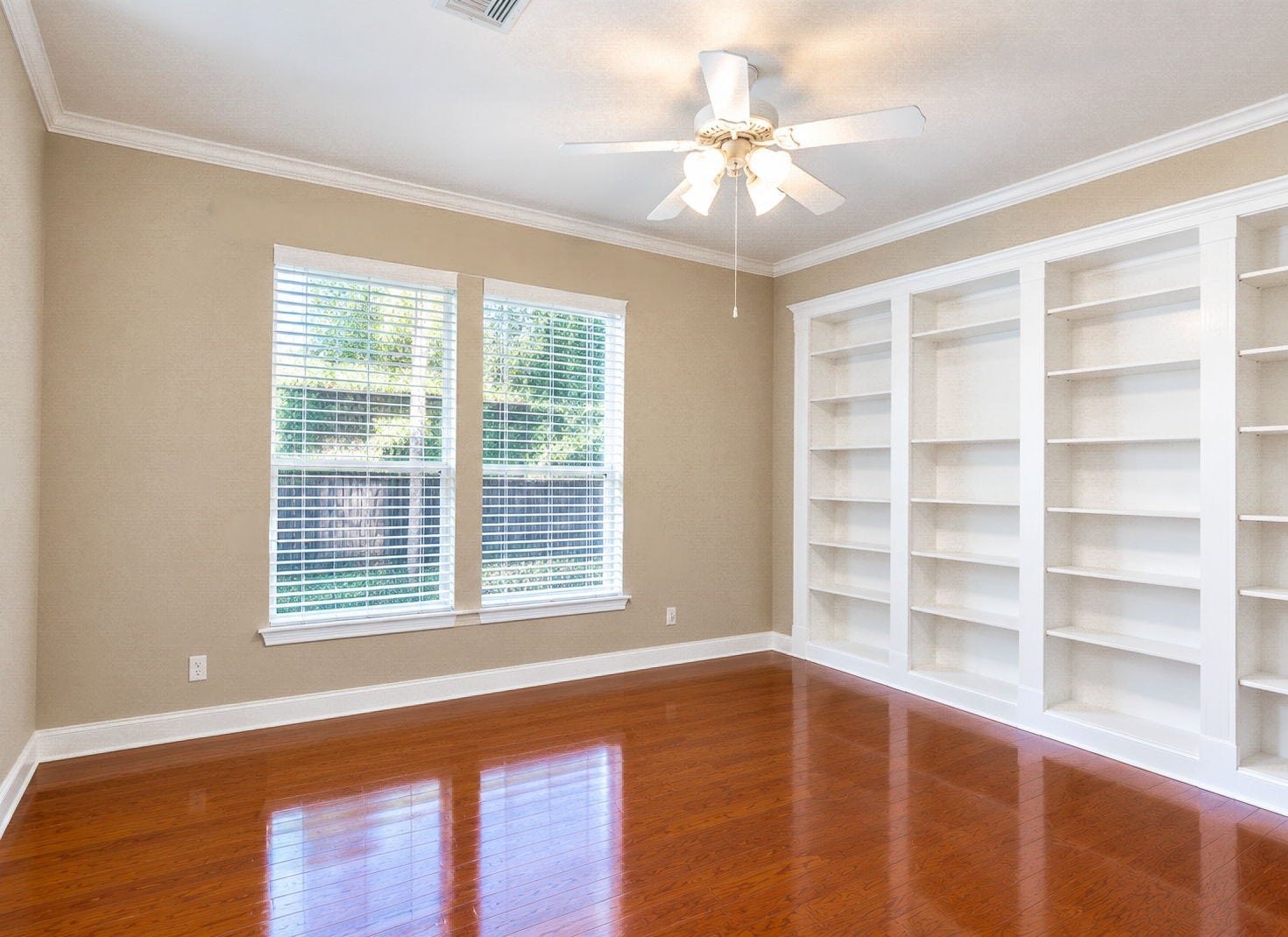 7514 Water Wood Trail, Kingwood, TX 77346 French doors leading to this study featuring elegant built-in shelving, warm hardwood floors, and ample natural light from large windows.