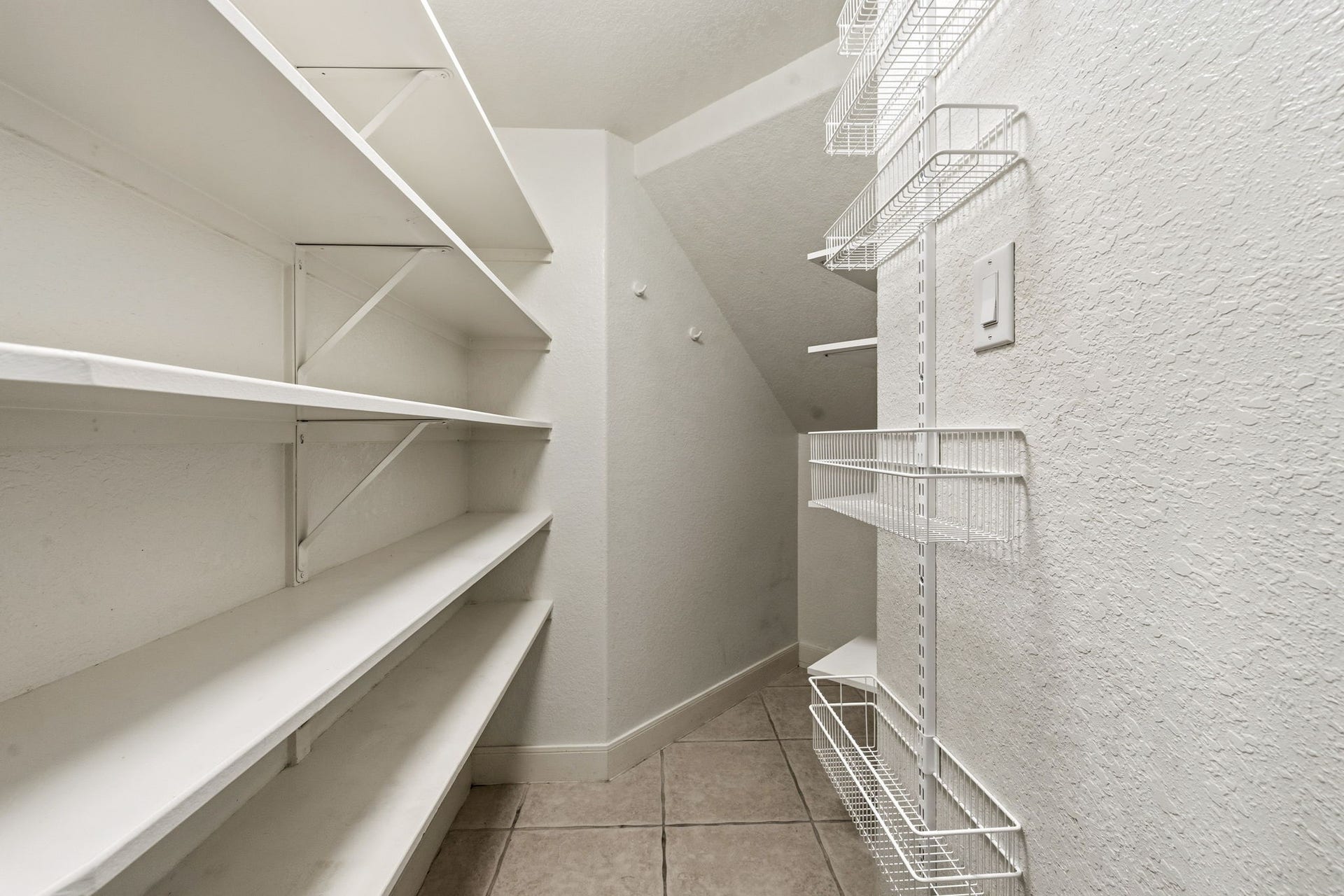 7514 Water Wood Trail, Kingwood, TX 77346 Spacious pantry with ample shelving and wire racks, perfect for organized storage and easy access to essentials.