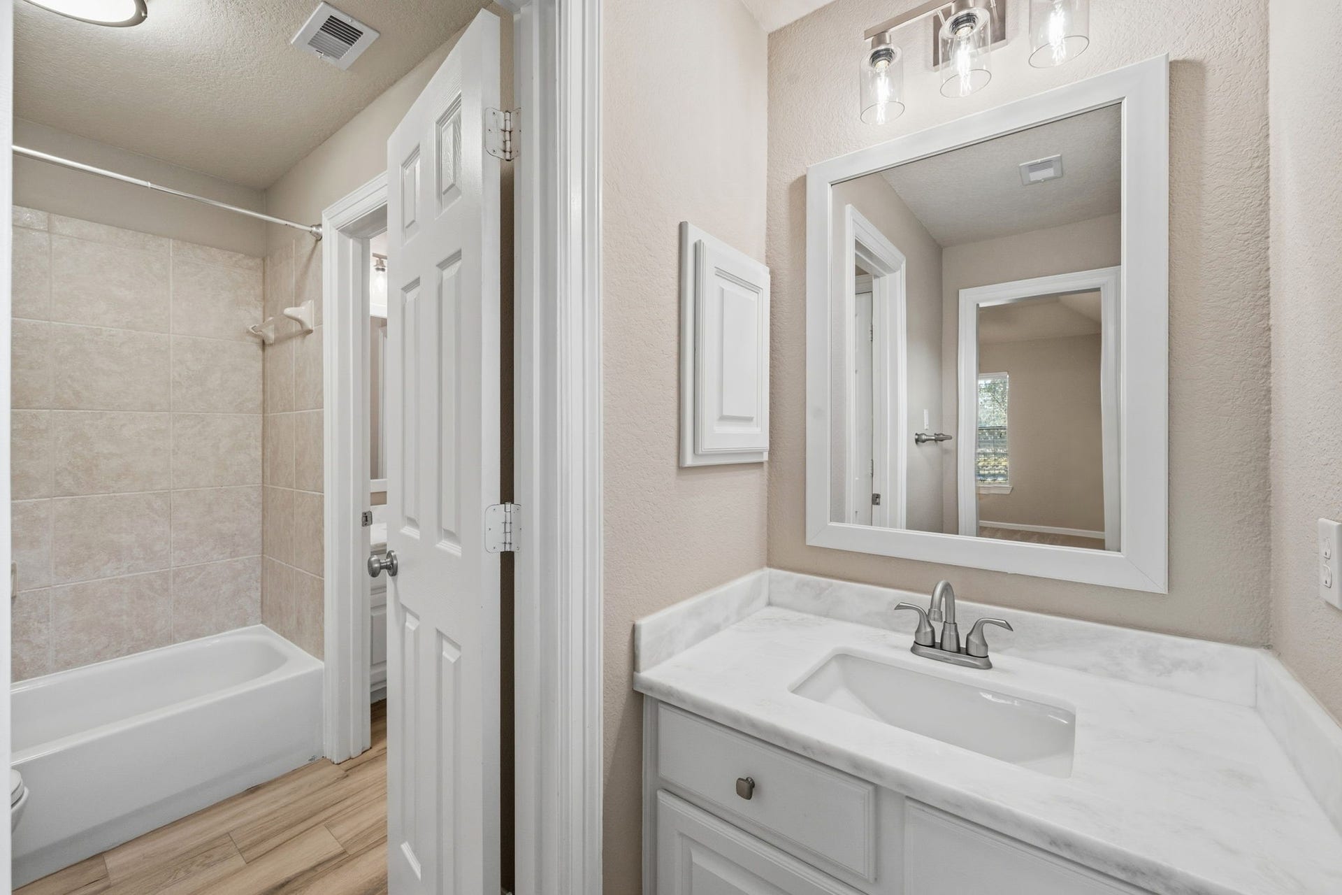 7514 Water Wood Trail, Kingwood, TX 77346 Elegant bathroom featuring a sleek vanity with updated countertop, modern fixtures, and a spacious tiled bathtub for a relaxing retreat.