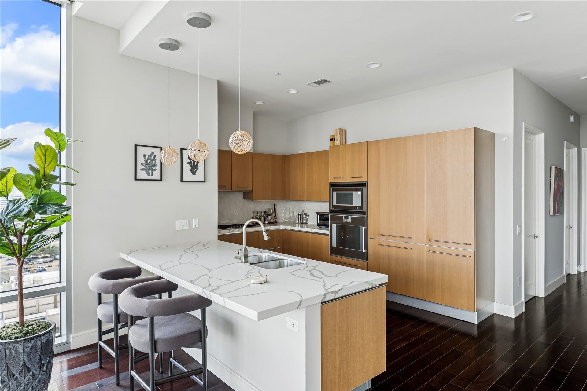Kitchen with large island, quartz countertops, pendant lighting, and full-height windows providing abundant natural light.