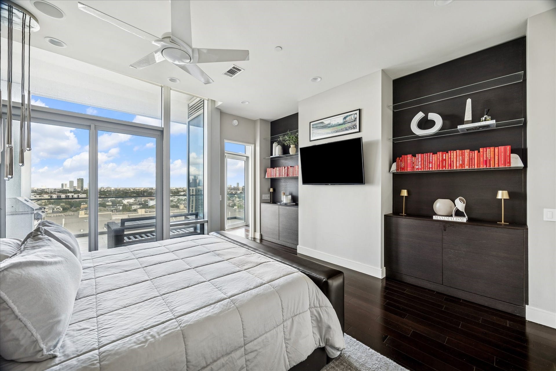 Primary suite with floor-to-ceiling windows, private terrace access, and built-in storage.