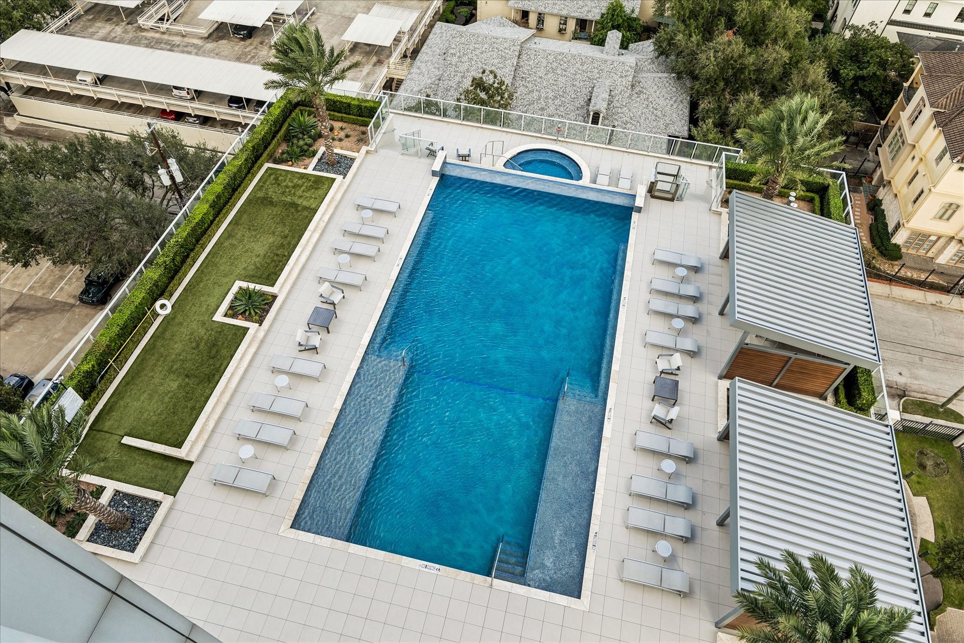 Aerial view of infinity-edge pool, spa, cabanas, and sun deck area.