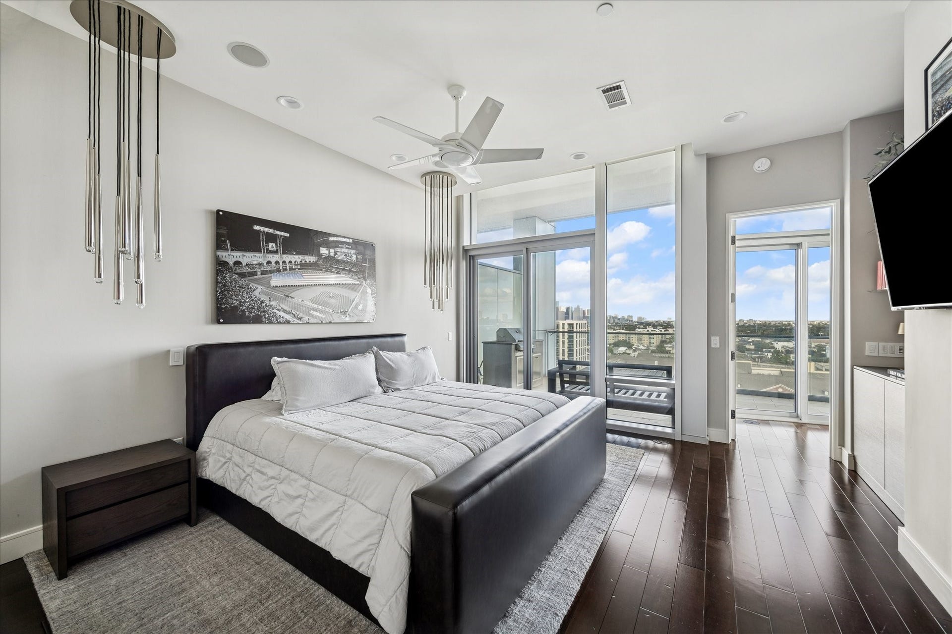 Primary bedroom featuring hardwood floors, recessed lighting, ceiling fan, and sliding glass doors to terrace.