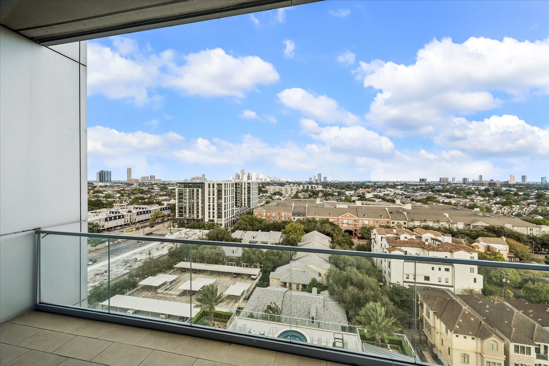 Private terrace with tile flooring, glass railing, and expansive southeastern views of the city skyline.
