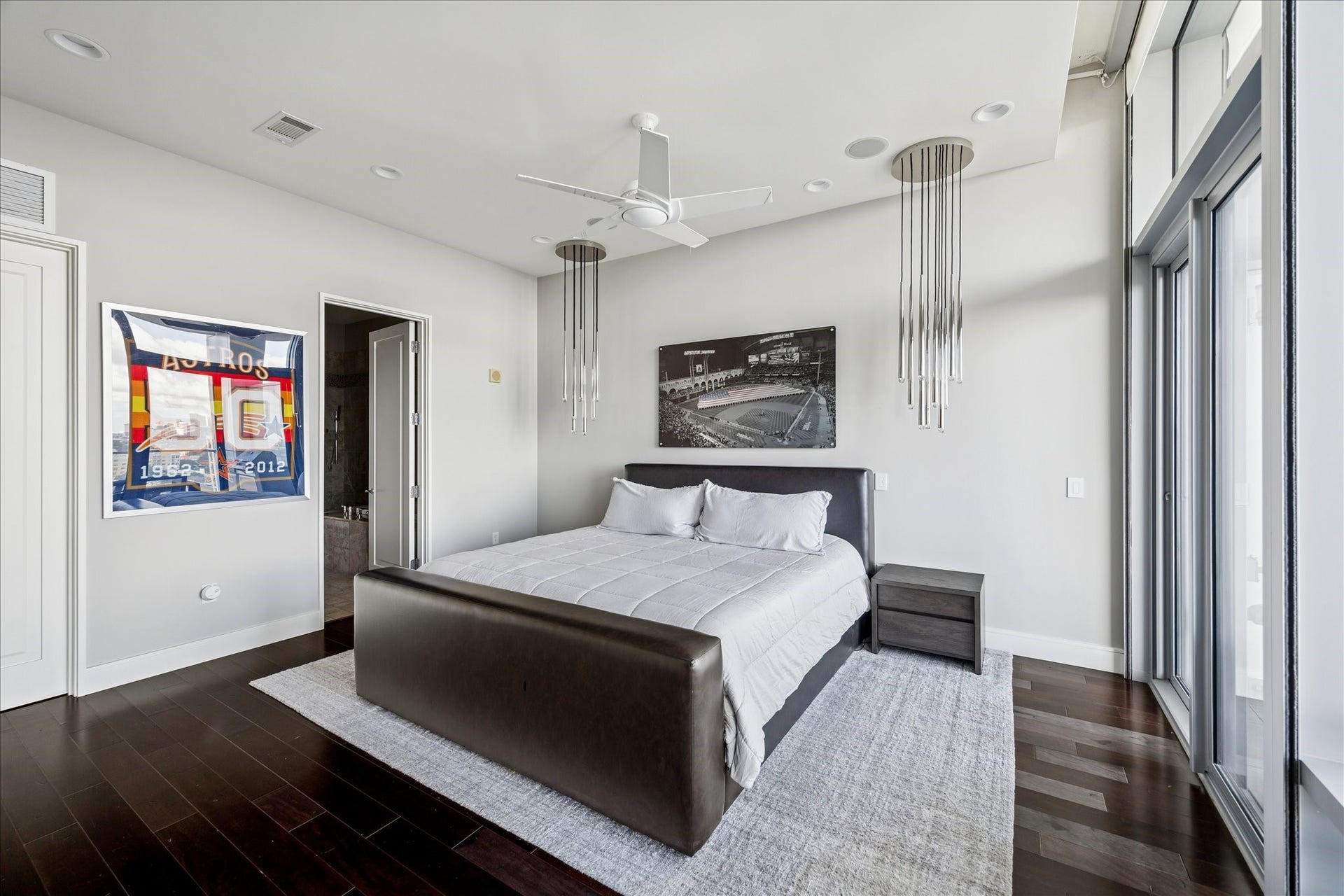 Primary bedroom with hardwood floors, recessed lighting, and access to ensuite bath and private terrace.