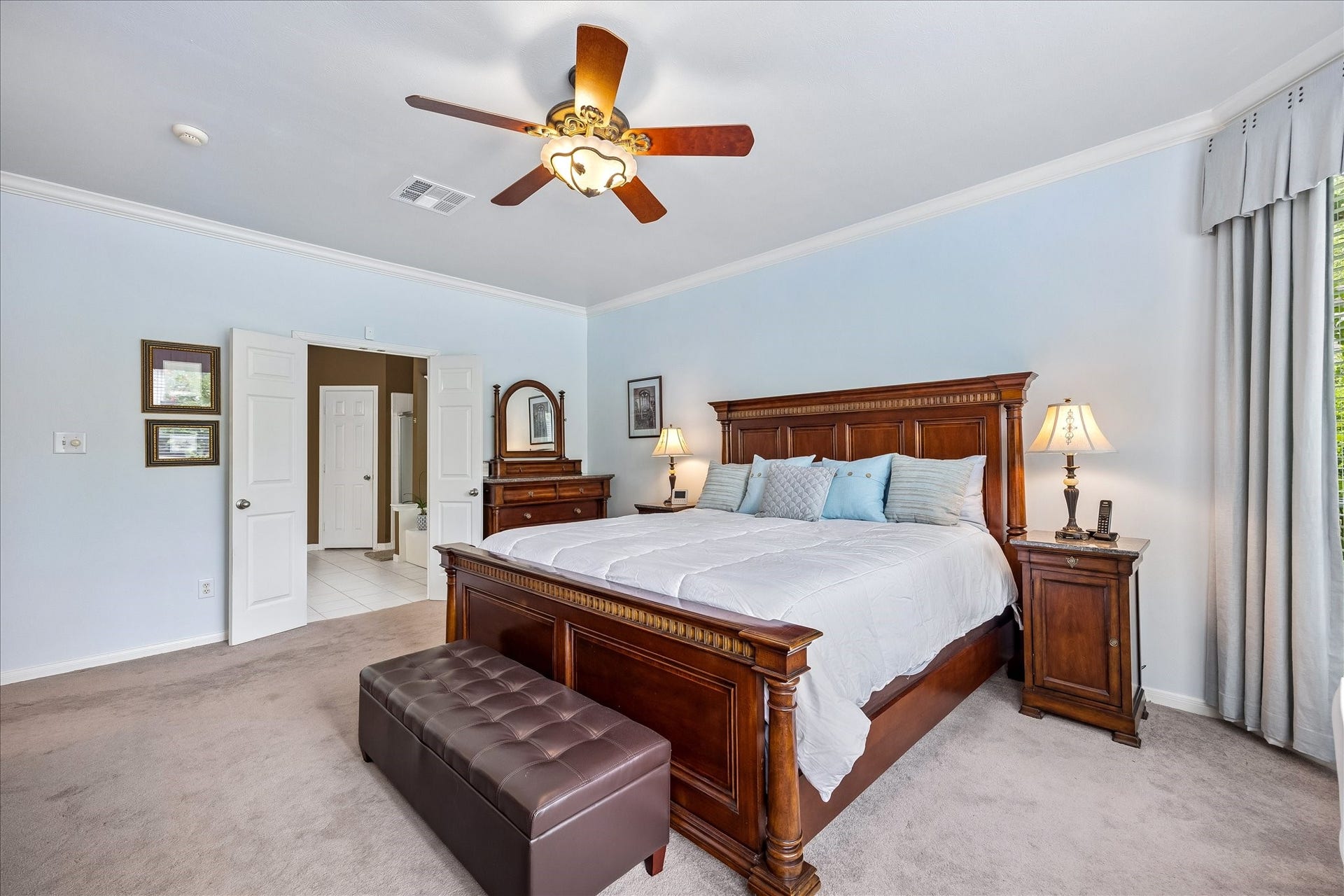 9618 Randon Lane, Missouri City, TX 77459 A view of the Primary Bedroom with double doors to the Primary Bathroom.