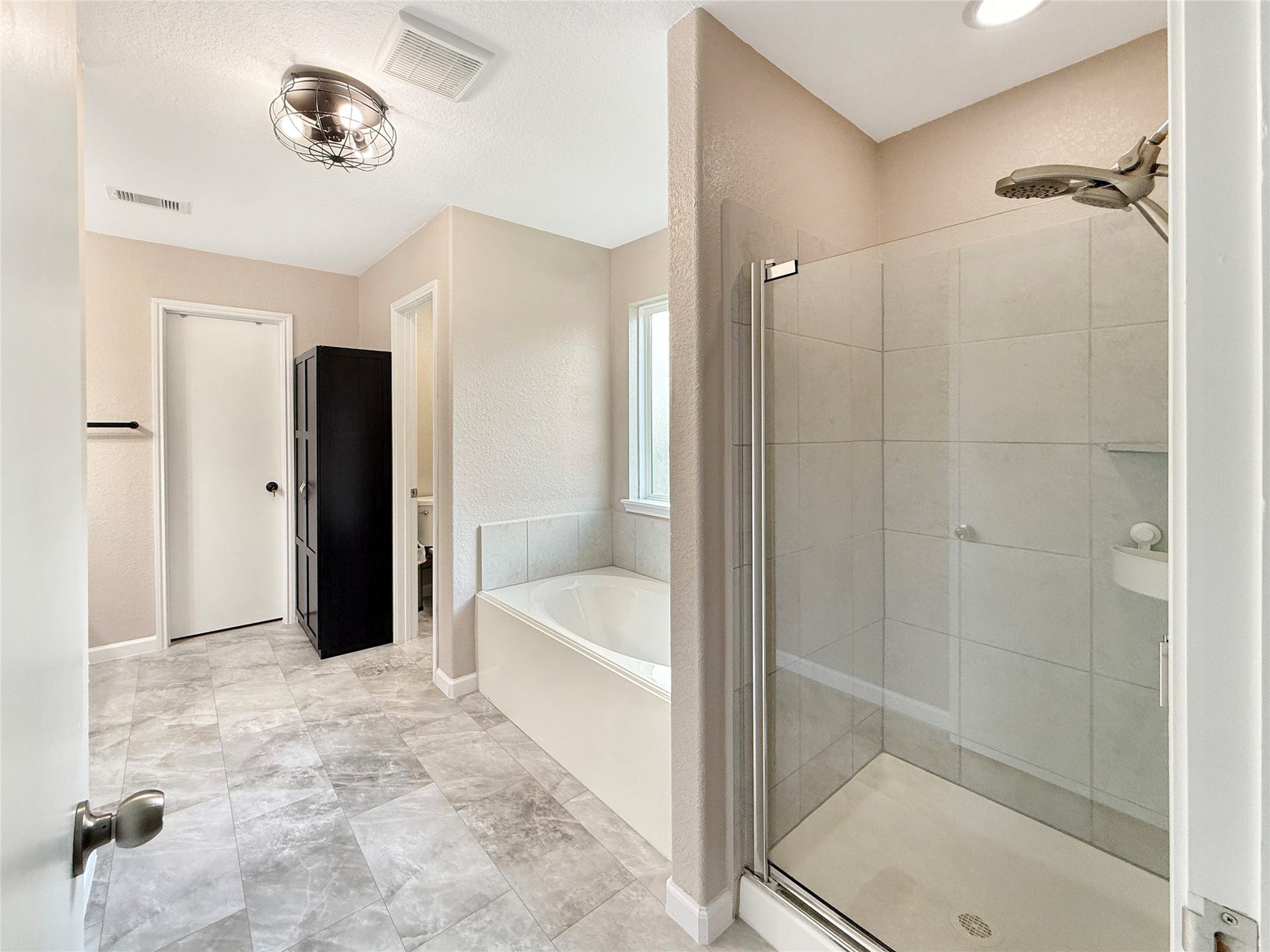 Primary bath with new flooring, a separate shower, and soaking tub offers an easy start to your morning and a relaxing place to unwind.