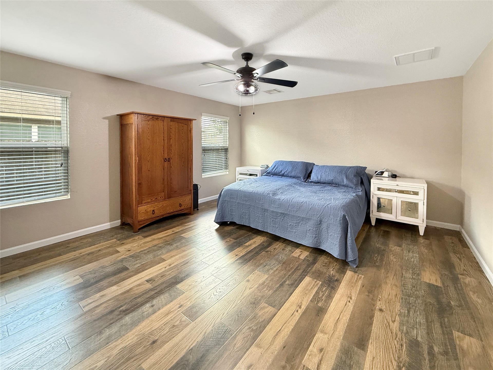 Spacious primary suite with hard-surface flooring offers a comfortable retreat to unwind at the end of the day.