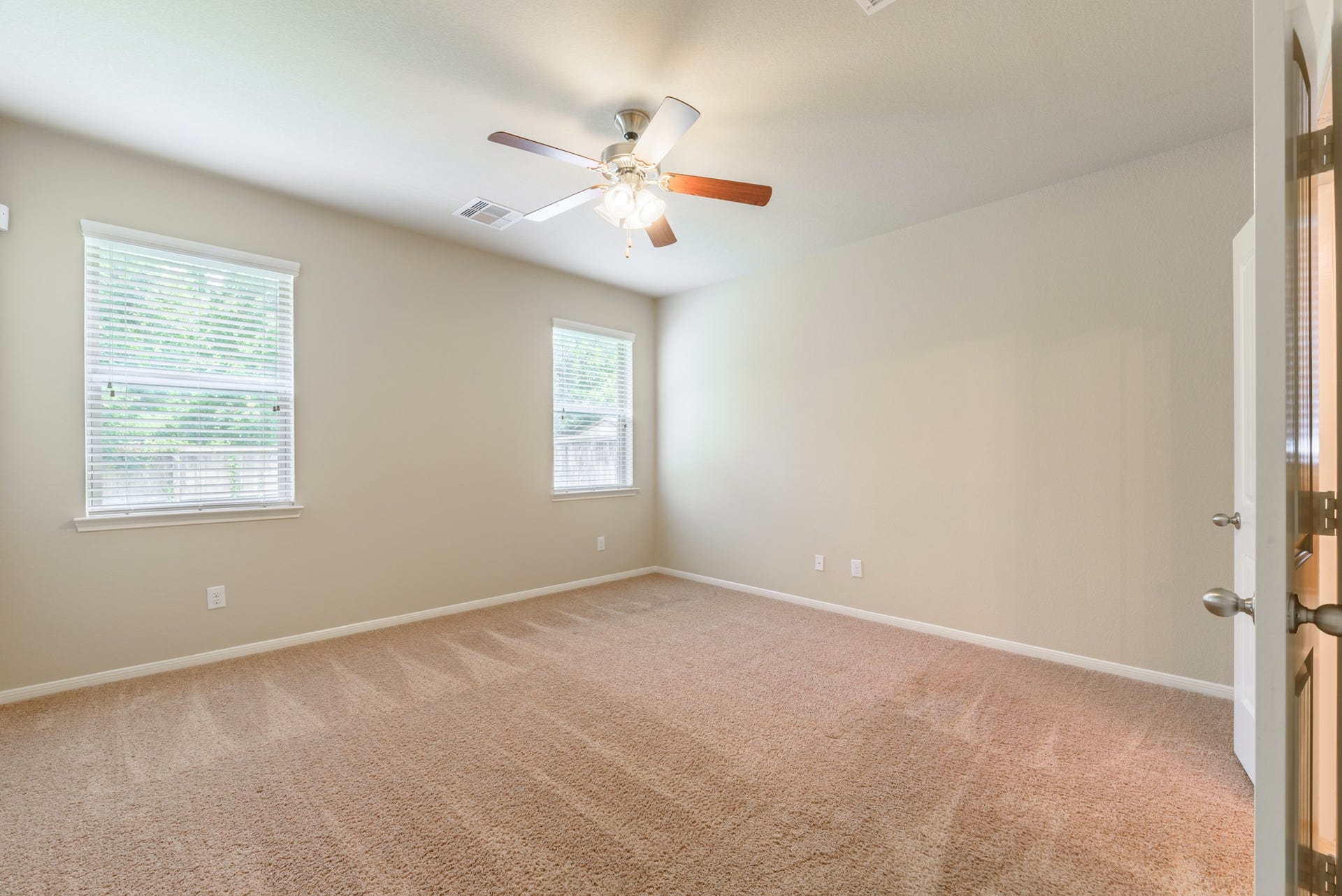 202 Black Swan Place, Magnolia, TX 77354 Primary bedroom has a ceiling fan, plush carpet and lots of natural light.
