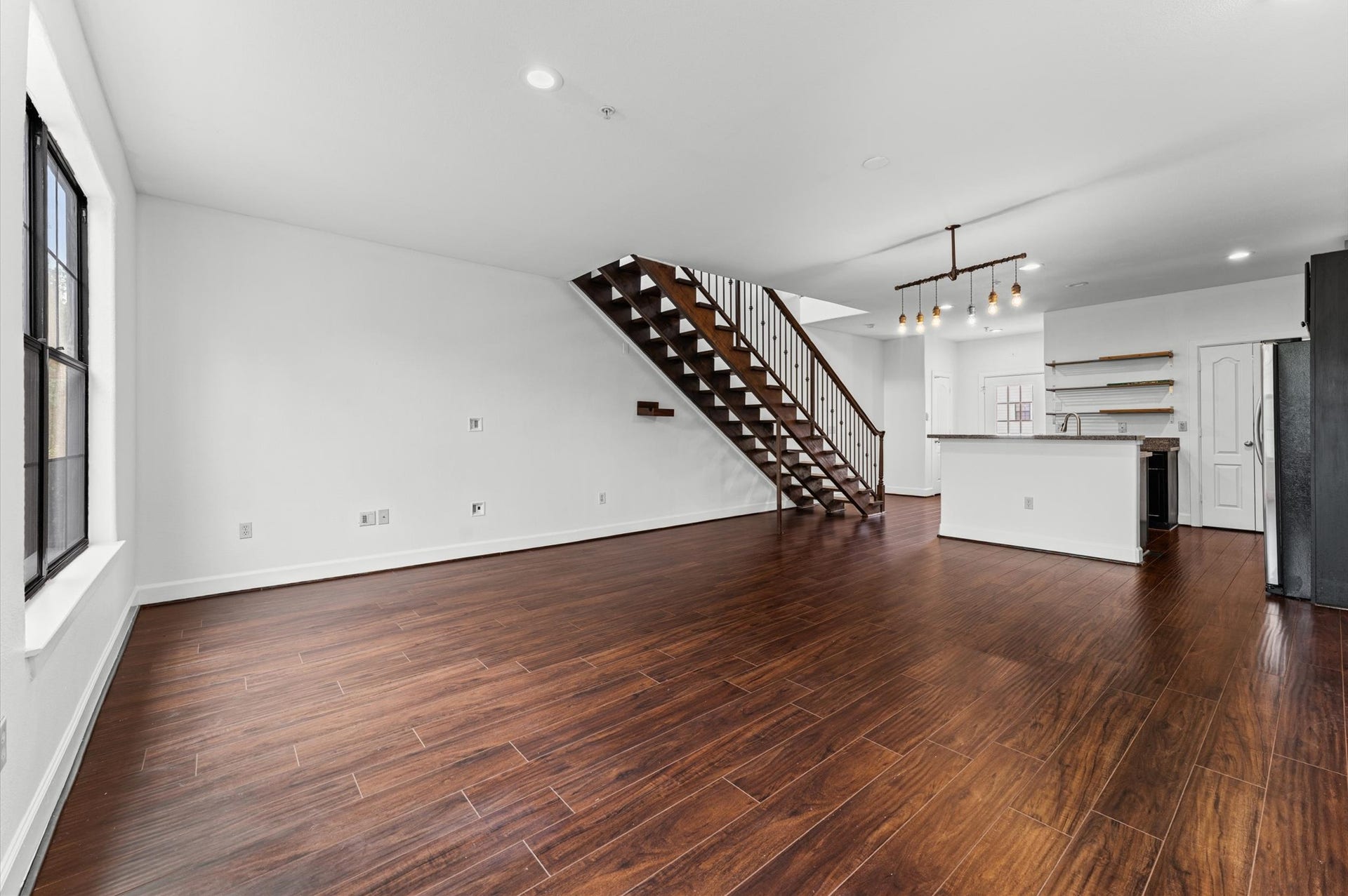 1602 Elgin Street, #10, Houston, TX 77004 The freshly painted interior features LVP floors, black-framed steel windows, and an open staircase that give the space a clean, modern character.