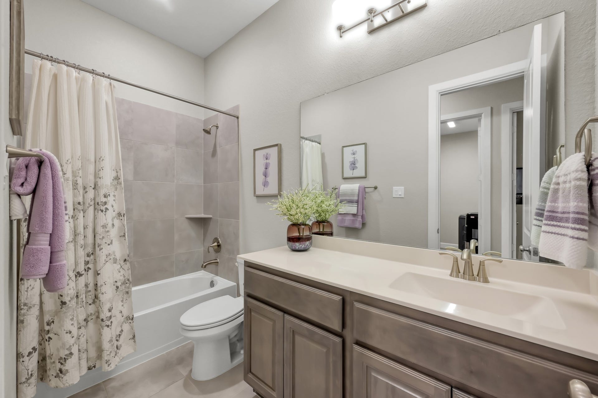 Spacious secondary bath with tub/shower combo, extended vanity, and neutral finishesideal for guests or family use.
