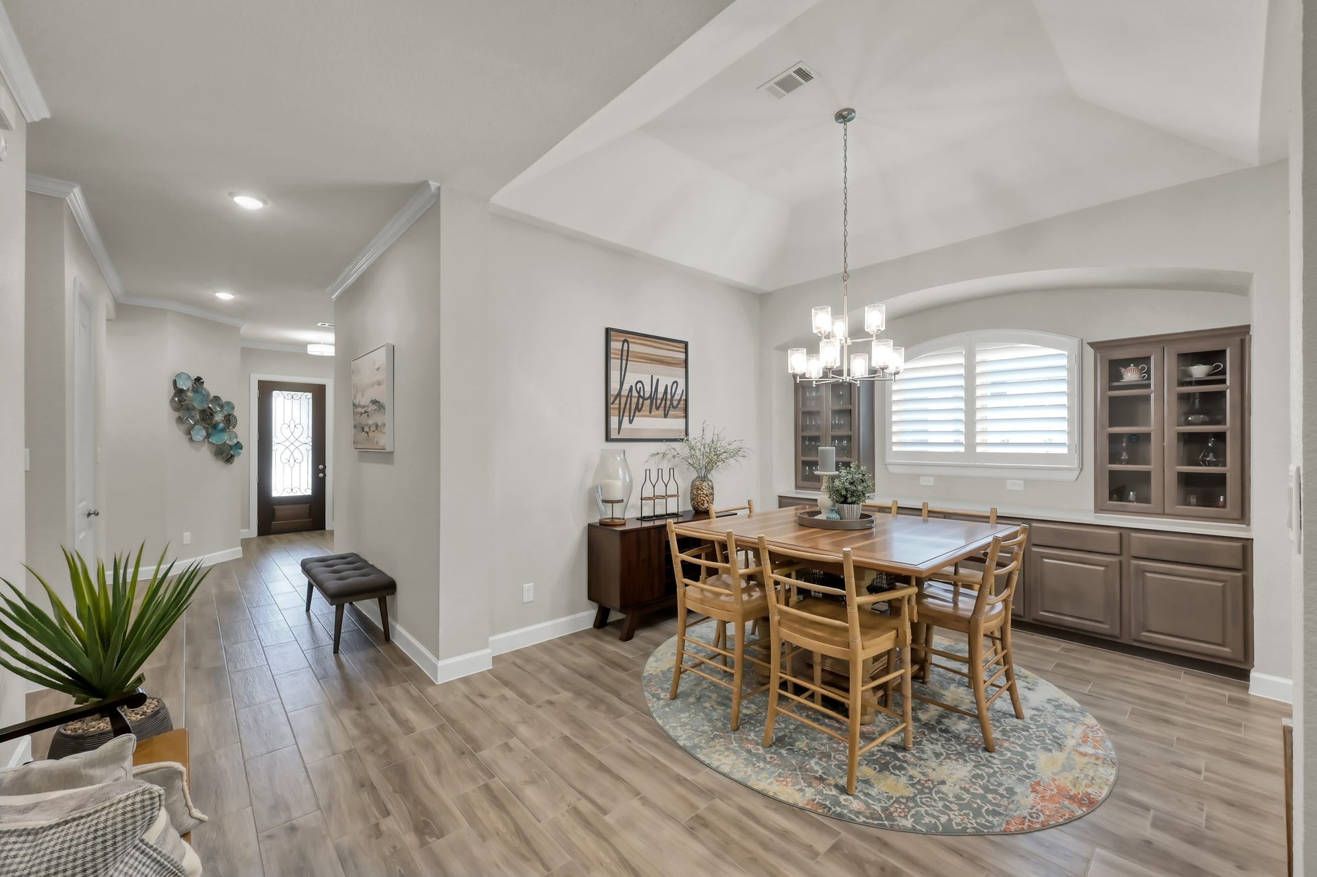 Spacious dining area with tray ceiling, elegant lighting, and built-in cabinetryperfect for gatherings and everyday entertaining.