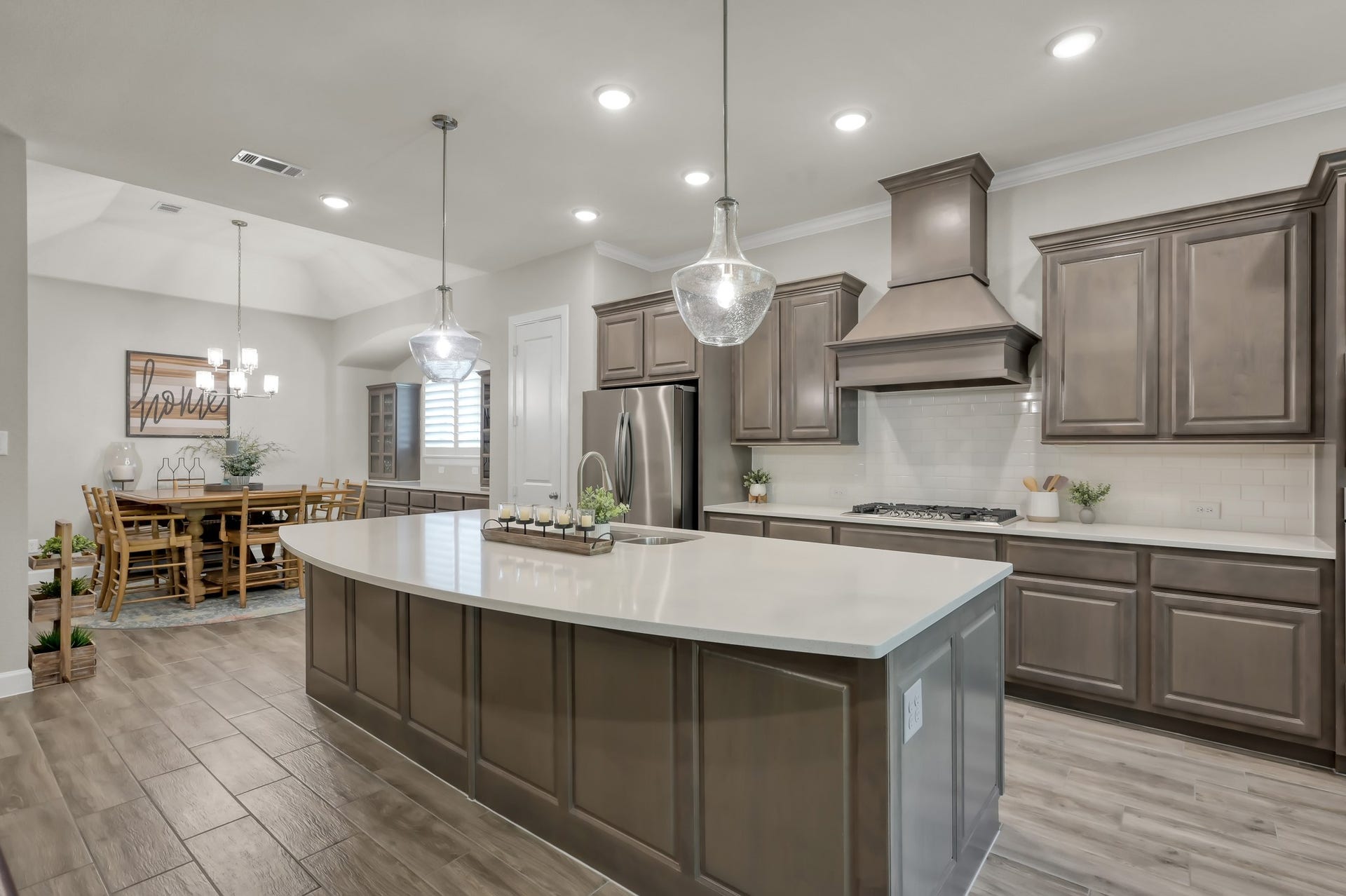 Stunning island kitchen with quartz countertops, pendant lighting, stainless steel appliances, and ample cabinetryopen to dining for seamless entertaining.