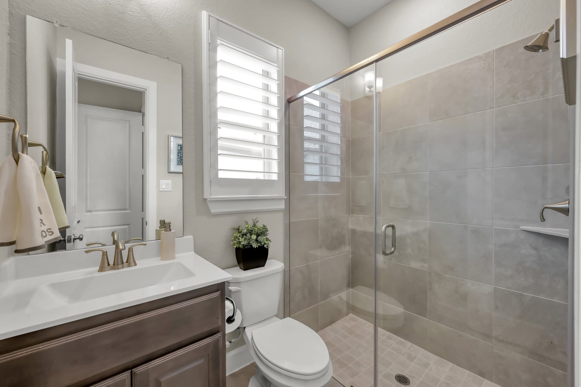 Well-appointed secondary bath with walk-in glass shower, neutral tile, and stylish finishes.