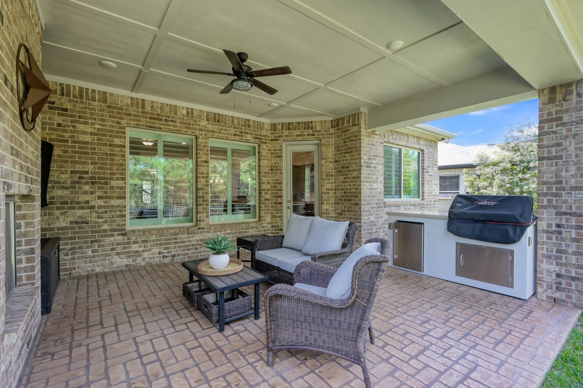 Covered patio with Custom outdoor grilling station with built-in BBQ grill and mini refrigerator.