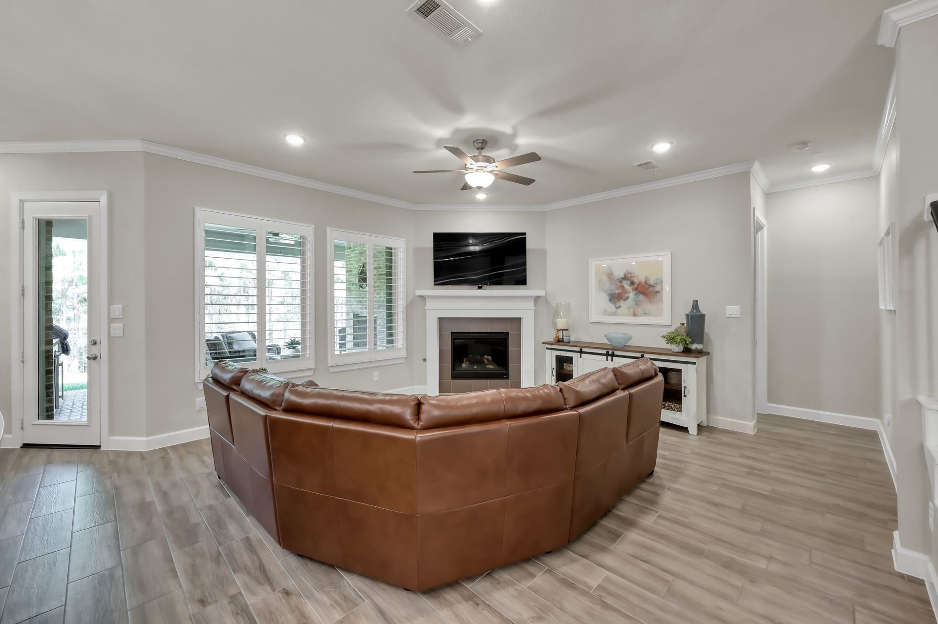 Spacious family room with abundant natural light, crown molding, and a cozy fireplaceperfect for relaxing or entertaining.