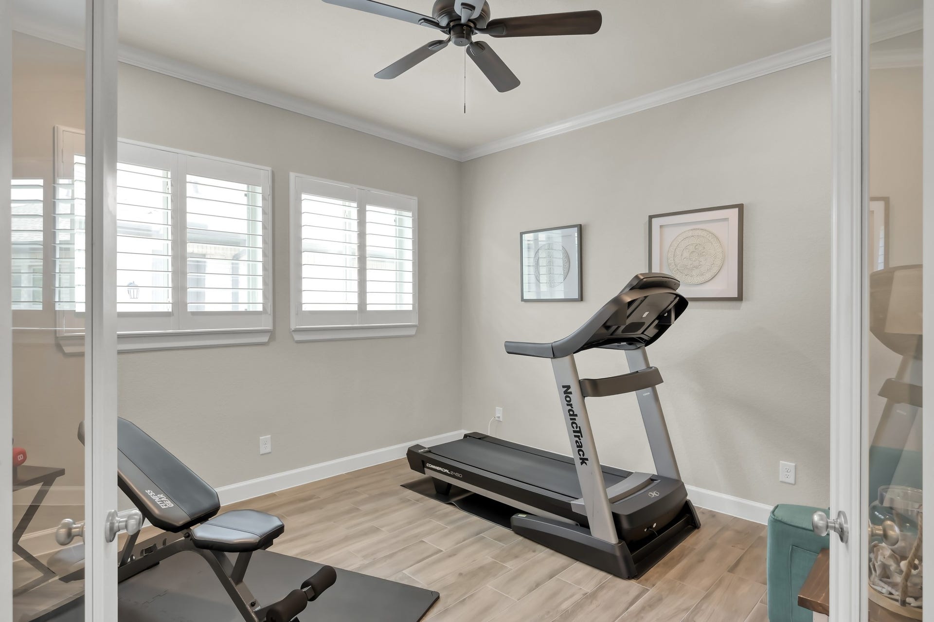 Versatile home office or flex space with French doors, wood-look flooring, and abundant natural lightperfect for a gym, study, or workspace.