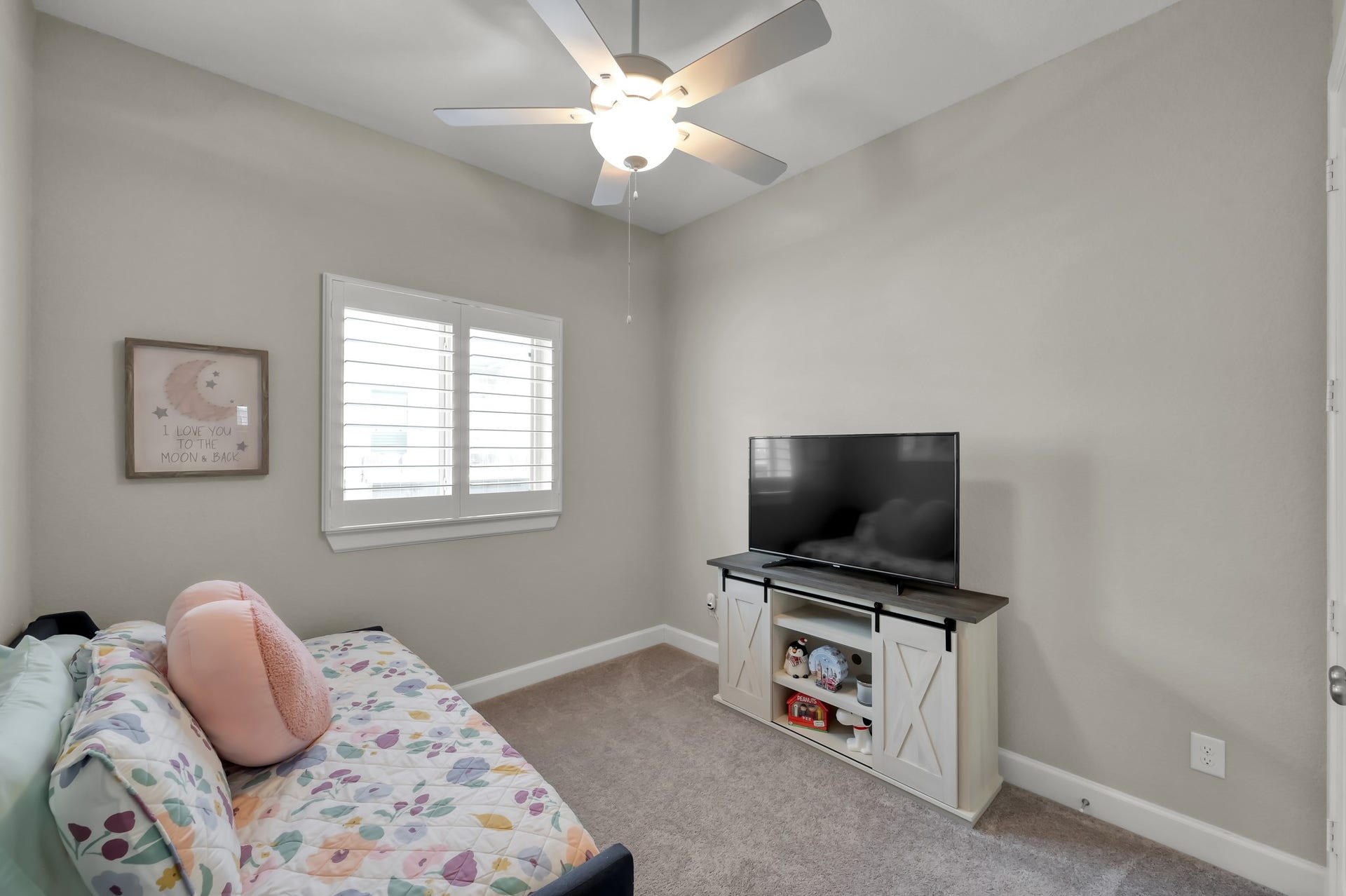 Comfortable secondary bedroom with soft natural light, neutral tones, and flexible space for guests or everyday living.