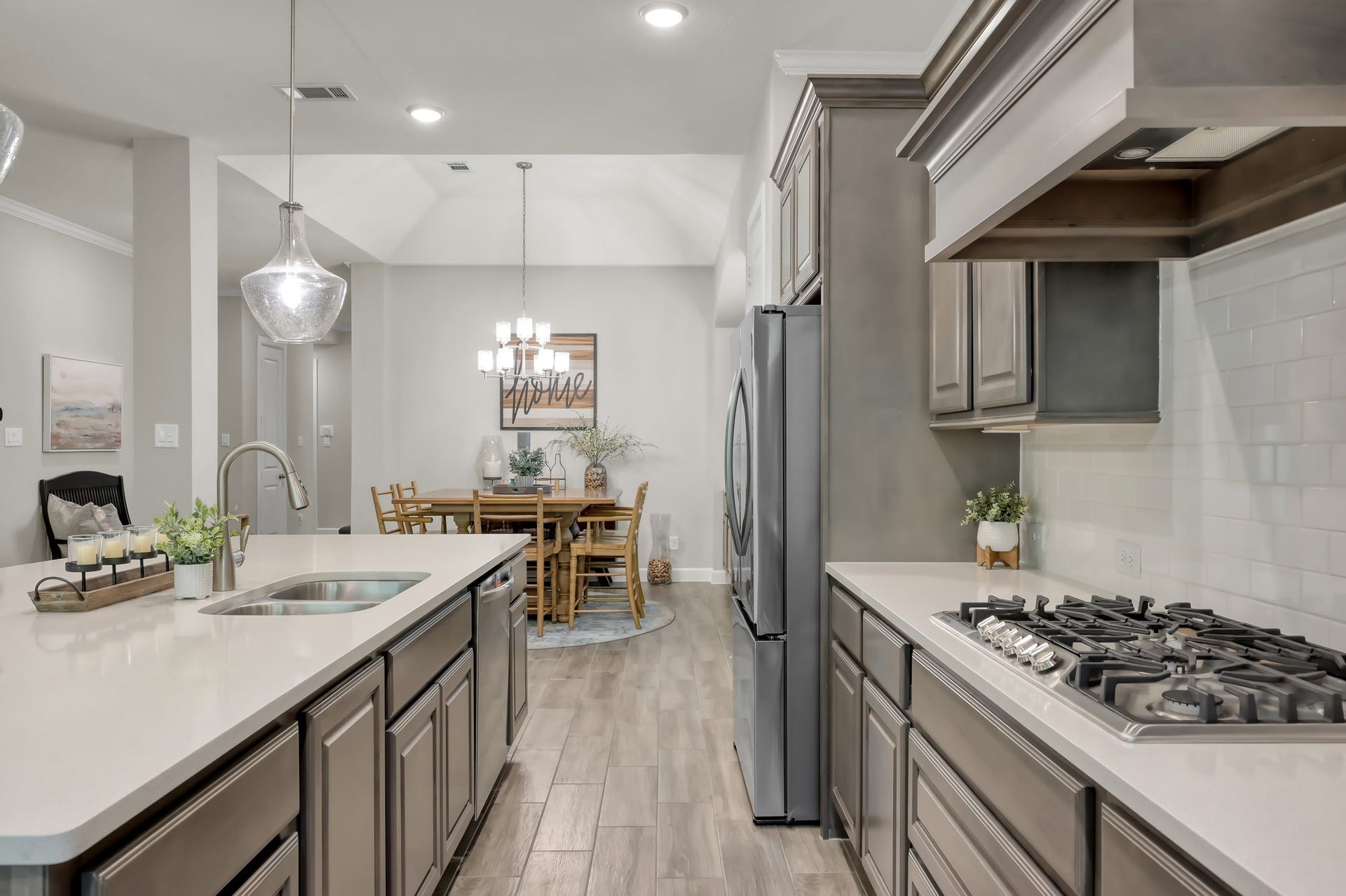 Kitchen features gas cooktop and spacious island with sink.