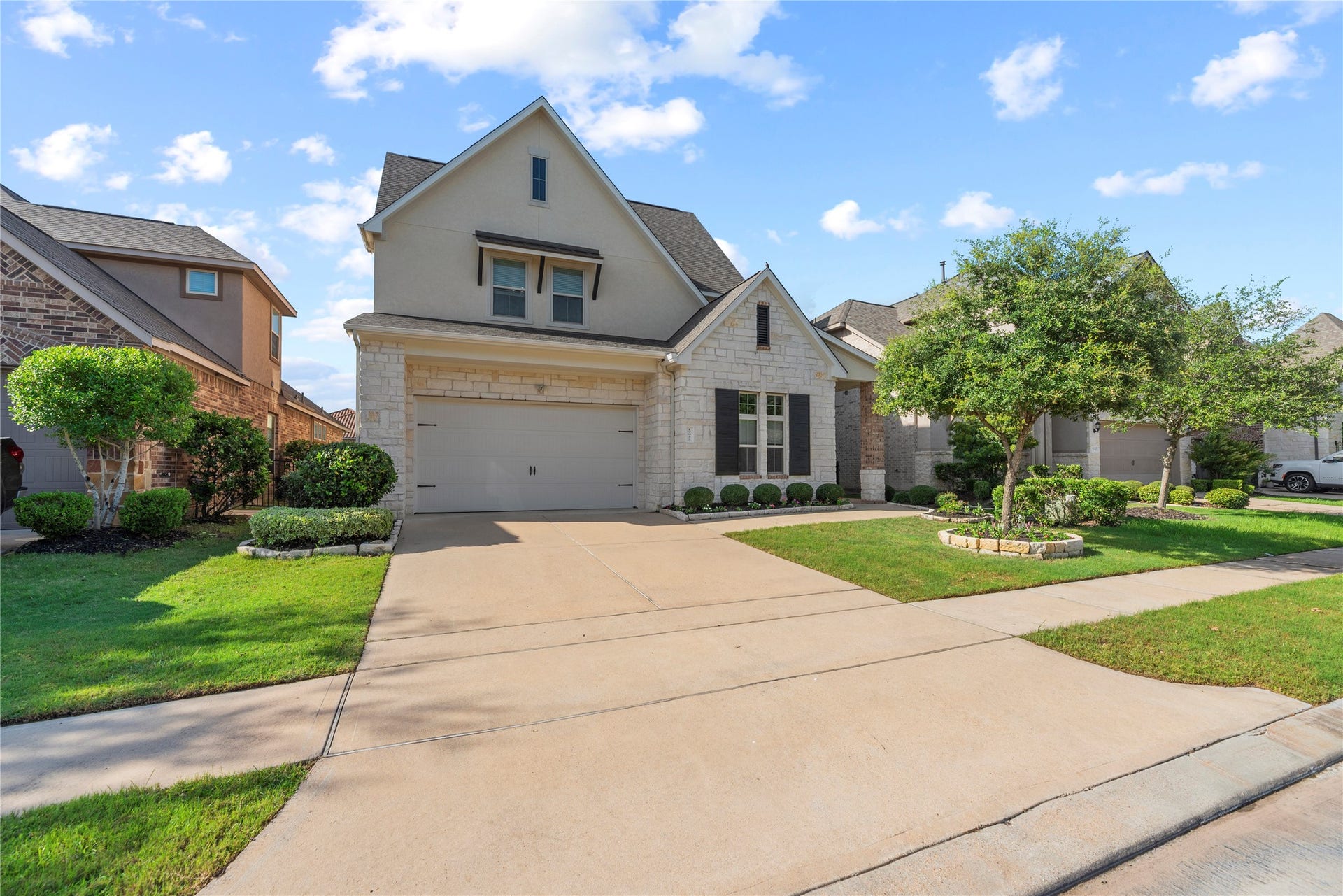 17922 Olde Oaks Estate Court, Cypress, TX 77433 The front elevation features light stone and stucco with the rest of the home showcasing a brick exterior.