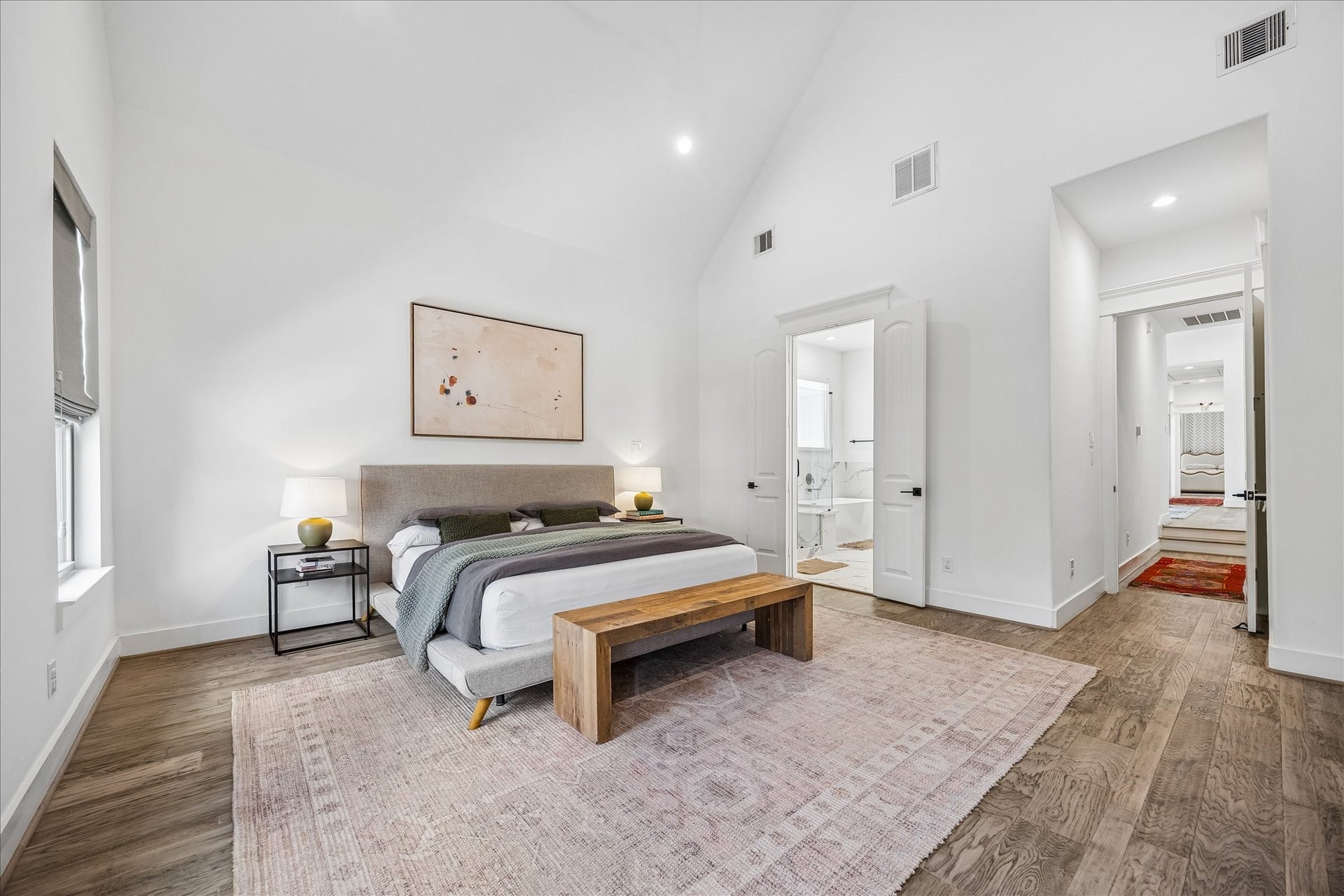 2320 Couch Street, Houston, TX 77008 This primary suite brings a little luxury to every morning and evening with a vaulted ceiling, engineered wood flooring, two walk-in closets and direct access to the ensuite bath, creating a private retreat that feels calm, spacious and easy to love.